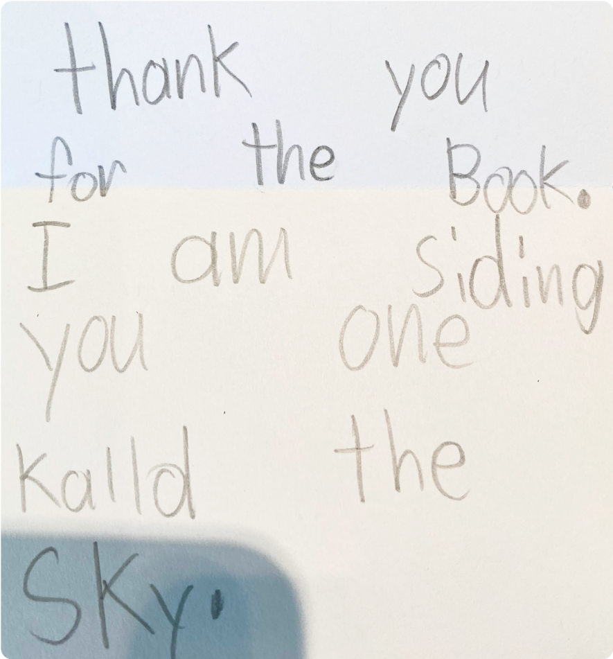 Handwritten note on paper with child's writing: "thank you for the Book. I am siding one kalld the SKY."