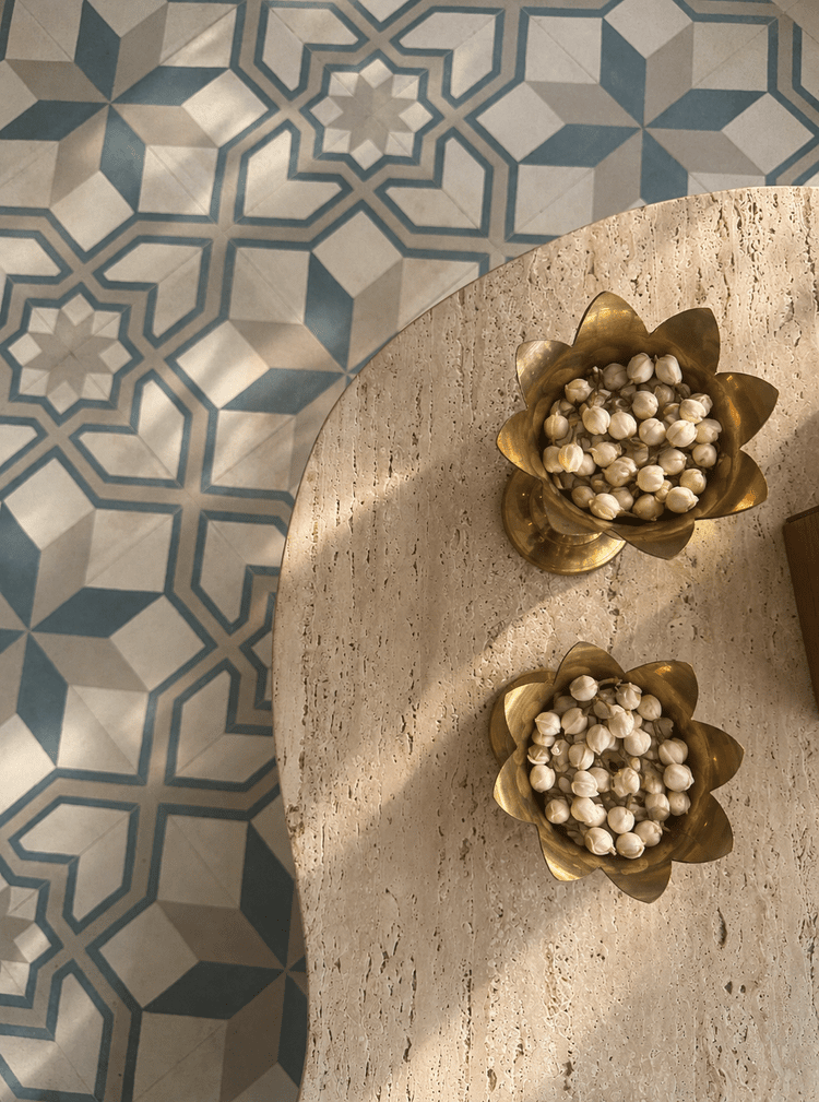 Jasmine in brass vessels beside patterned tile
