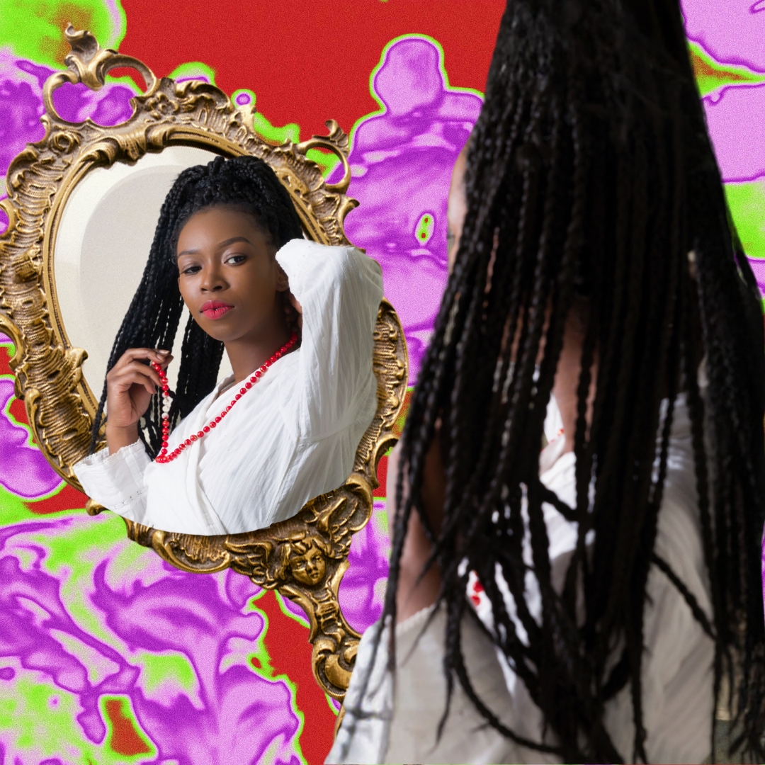 A Black person looks into a gold-framed mirror. They have long braids and are wearing a white garment with a red necklace. They are pictured against a pink, green, and red abstract background.