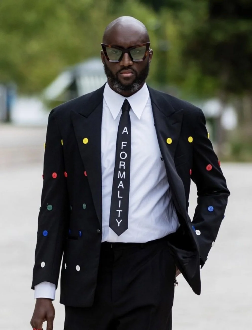 Virgil Abloh in a suit and tie that reads "A FORMALITY"