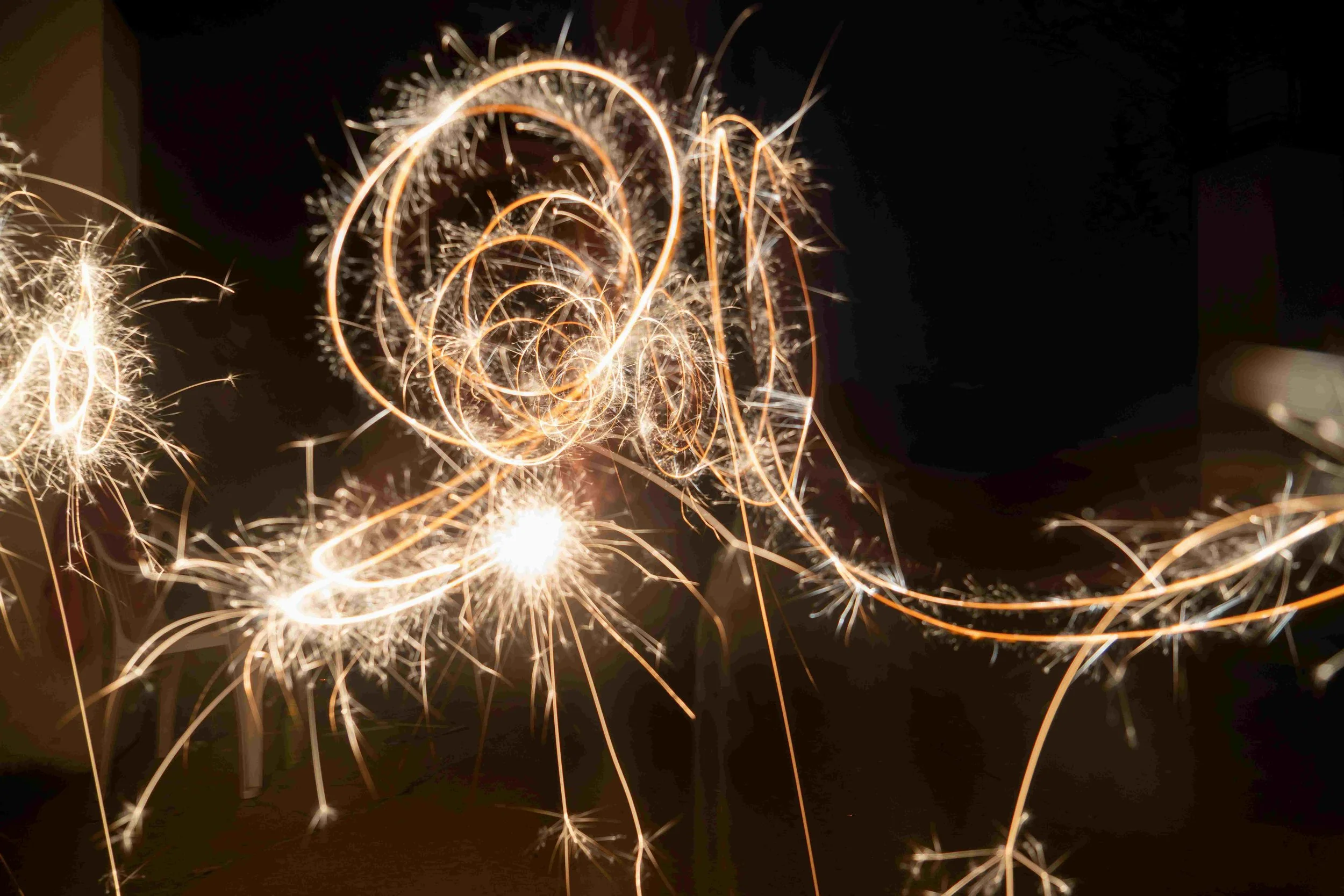 Sparklers making a pattern on a dark background.