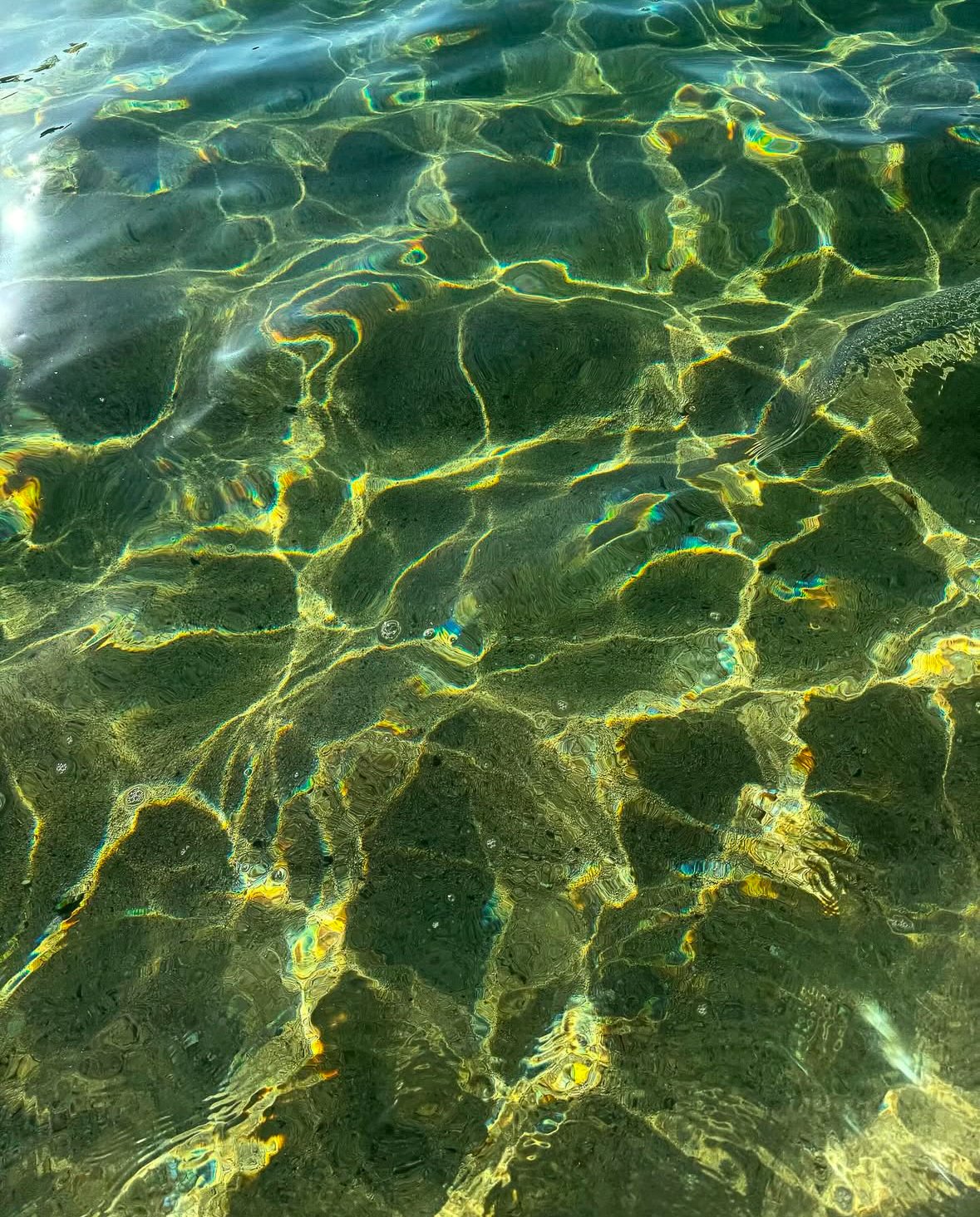 Sunlight reflecting in rippling green-blue water