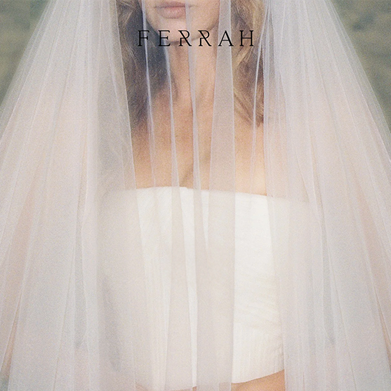 A woman wearing a strapless white wedding dress with a long, sheer veil covering her face. Ferrah logo at top center of page.