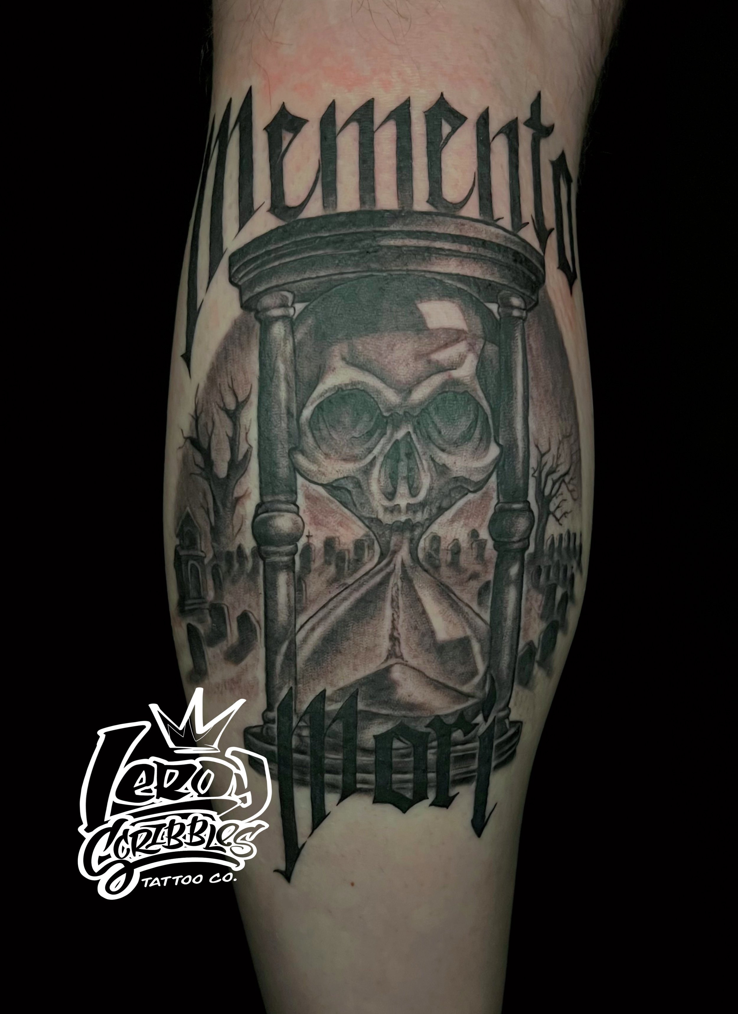 Black and grey momento mori tattoo on mens calf, gravesite background tattoo one by local tattoo shop artist Leroy scribbles Arizona tattoo artist