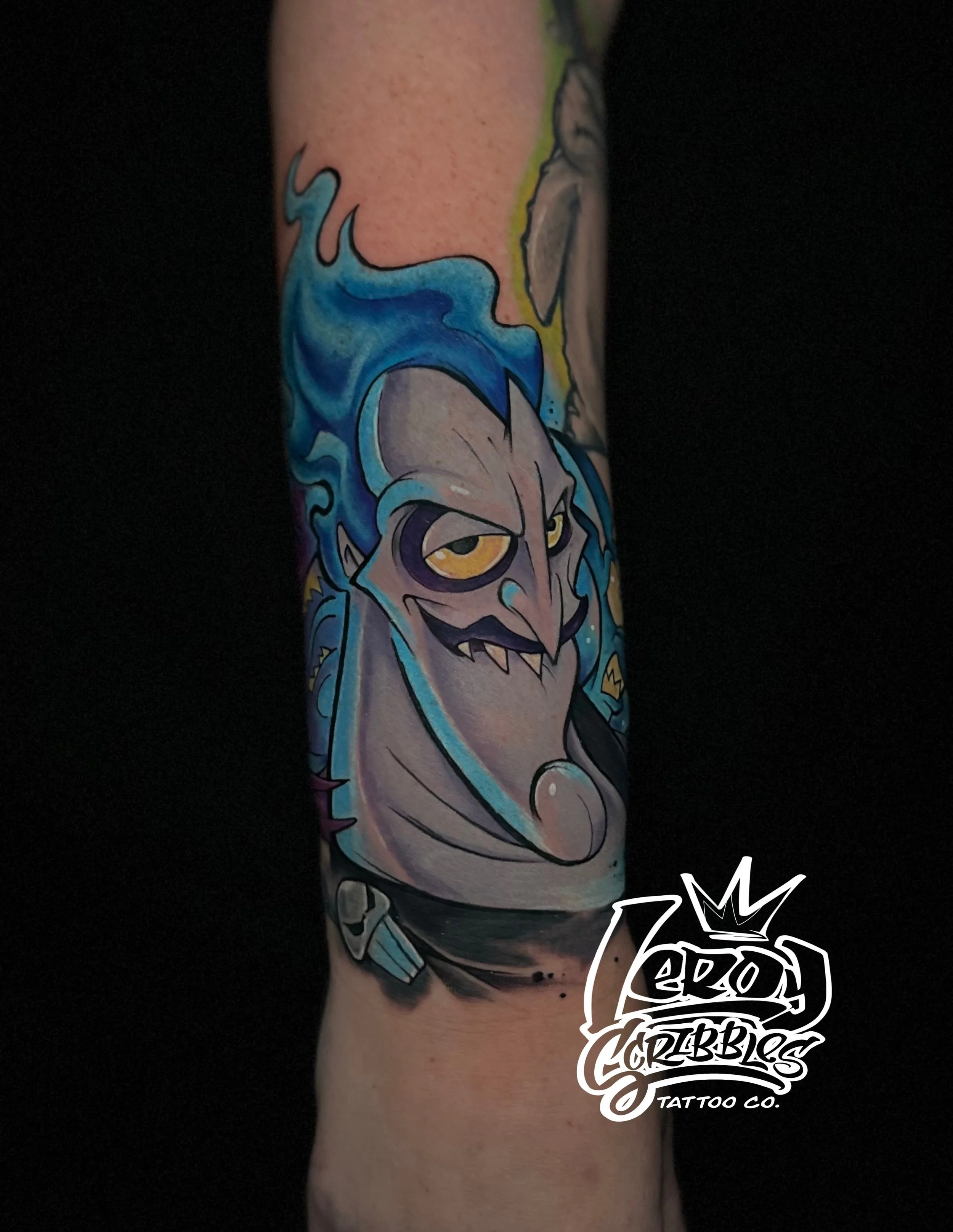 Animated classic hades, from disneys hercules tattoo on a woman’s forearm, in full color done by Arizona tattoo artist Leroy Scribbles