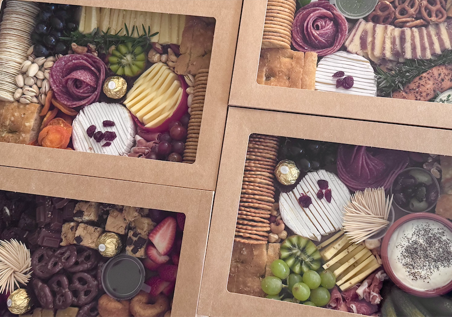 A collage of four images showing different foods. Top left: fresh strawberries, blueberries, raspberries, chocolate bark, and candied ginger. Bottom left: green grapes, red grapes, and grape jelly. Top right: slices of bread, a bowl of creamy dip garnished with chives, smoked salmon, slices of roast beef, cheese, and assorted nuts. Bottom right: a cup of yogurt topped with chocolate shavings, and slices of bread, cheese, and meats.