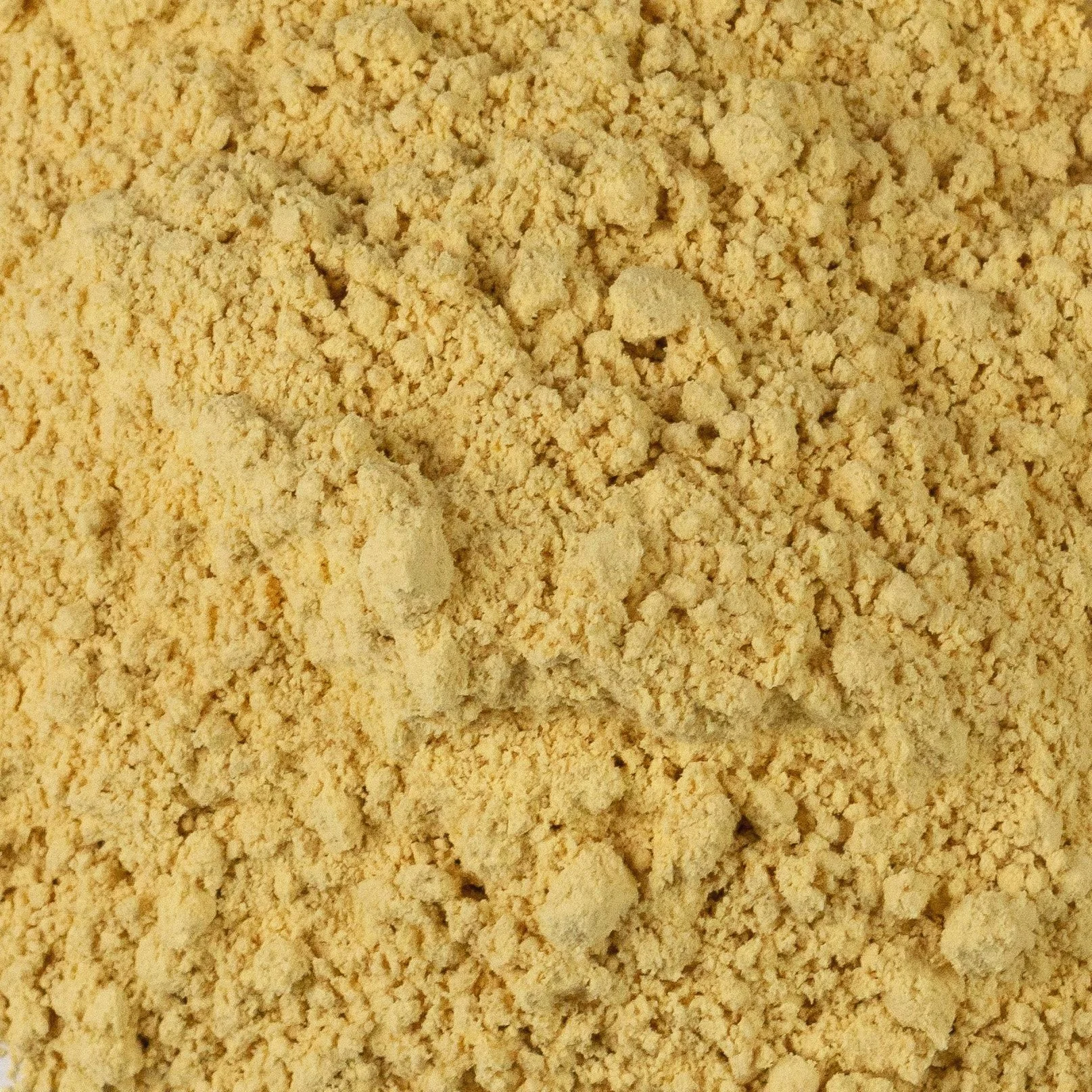 Close-up of yellow chickpea flour with a coarse texture.