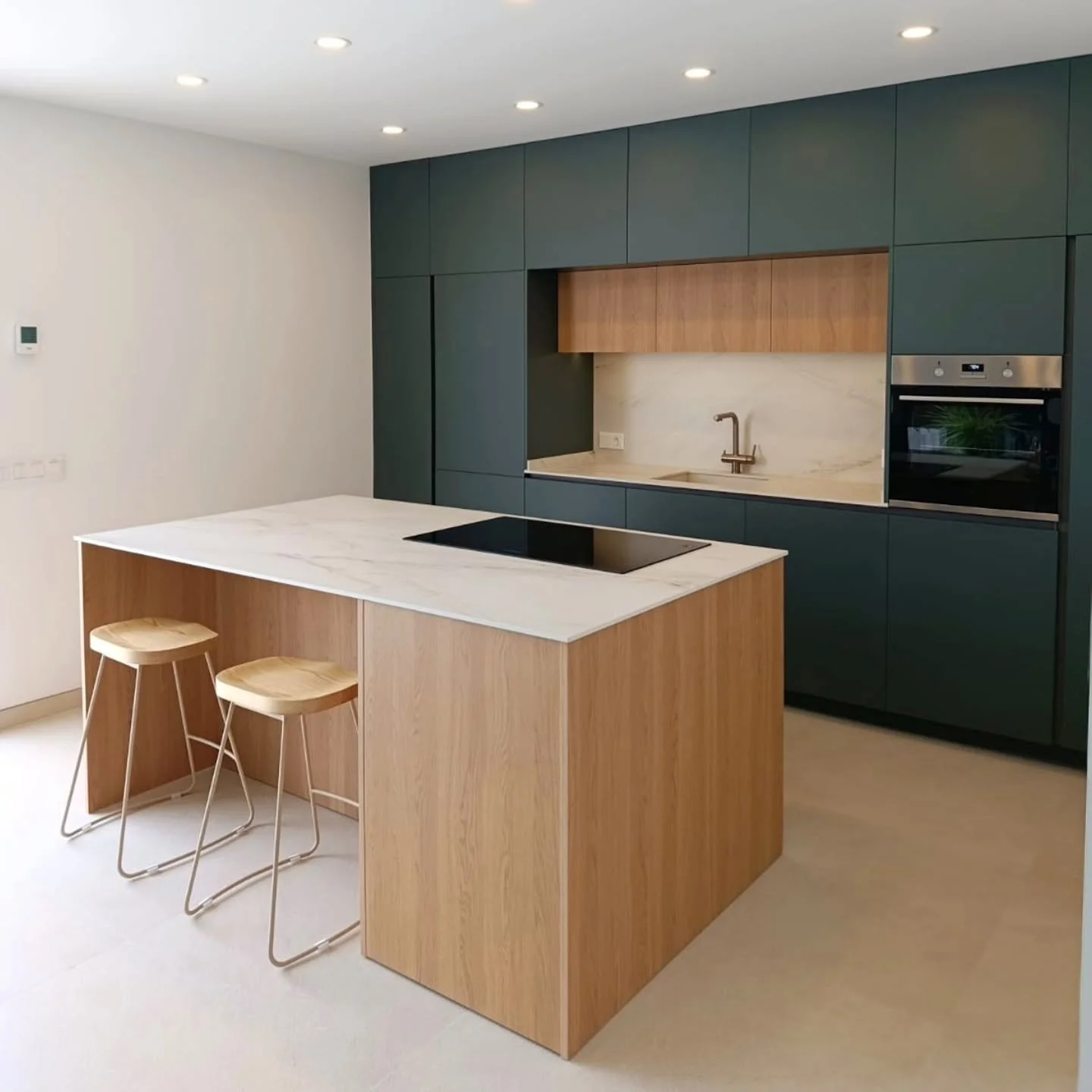 Proyecto de cocina que se caracteriza por un dise&ntilde;o moderno, minimalista y funcional,donde combinamos muebles en tonos verdes oscuros con  madera de roble natural. La isla central, con placa de inducci&oacute;n y espacio para dos taburetes, si