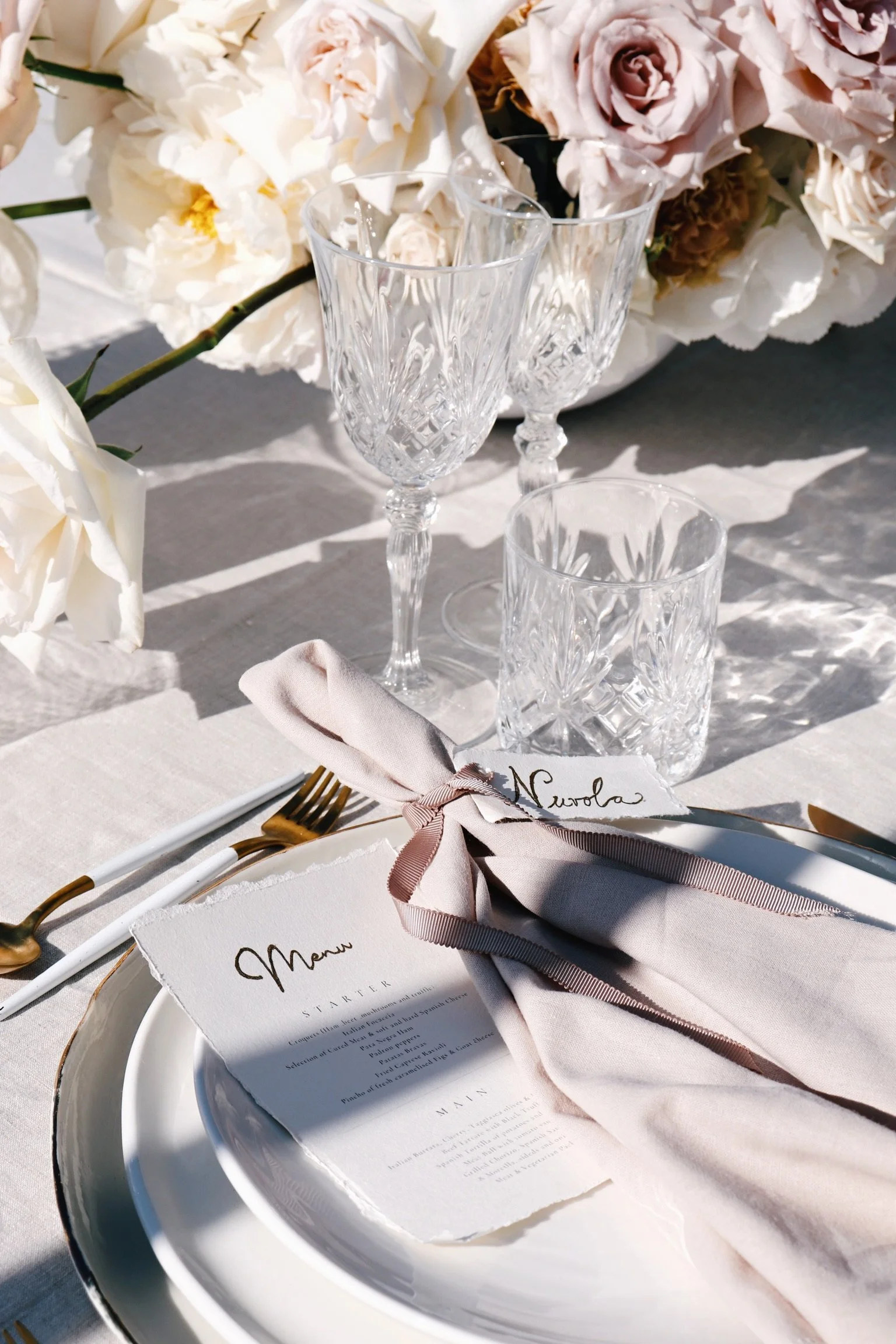 Intimate dinner setup with suspended florals and elegant place settings, vow renewal Ibiza