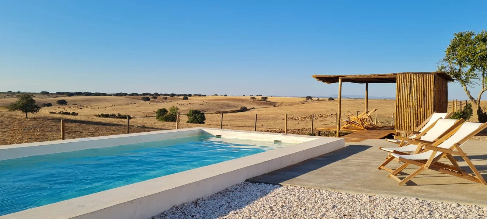 Piscina com cadeiras e vista.jfif