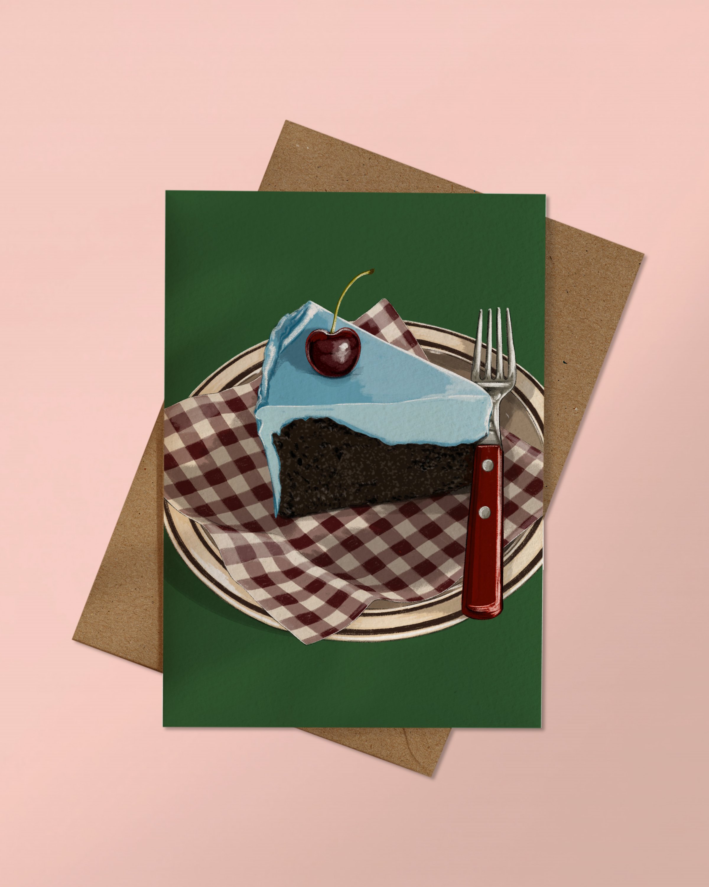 A6 Greeting Card of a slice of cake with a dark cherry on a gingham napkin on a dark green background stacked on a kraft brown envelope on a pink background.