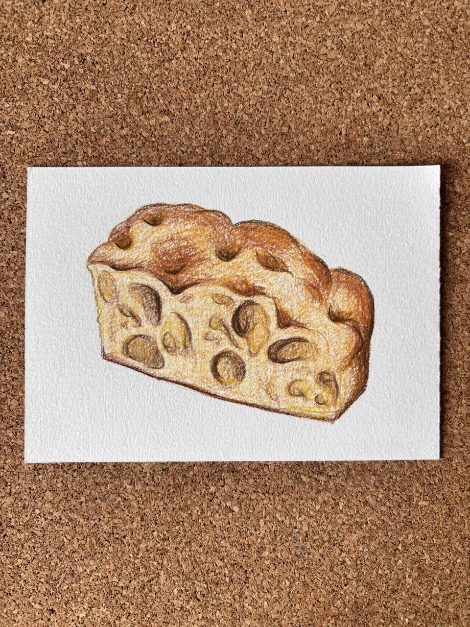 A detailed colored pencil drawing of a slice of cheese with holes, placed on white paper on a corkboard background.