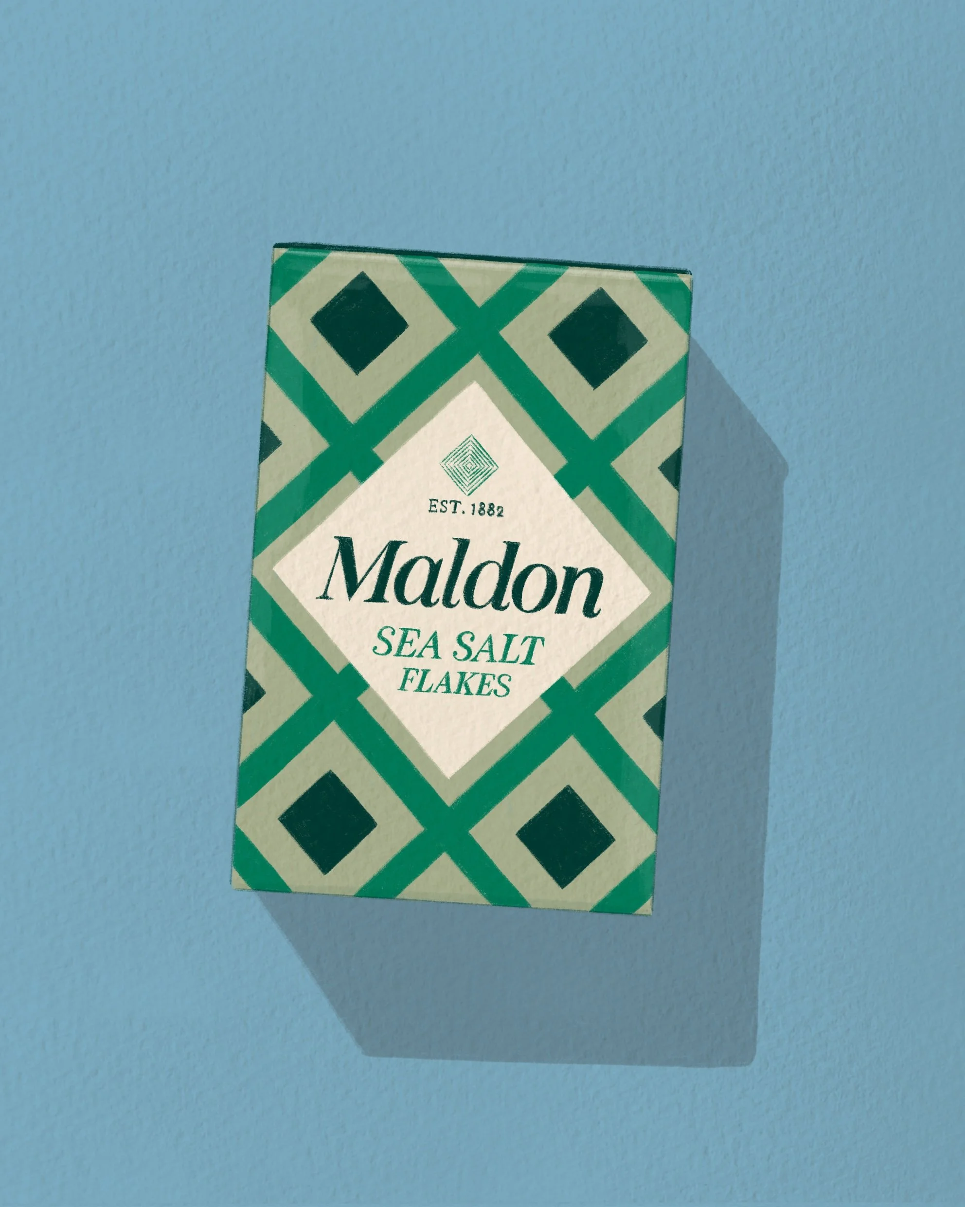 Part of a box of Maldon sea salt flakes with a geometric green pattern on the packaging, shown against a blue surface.
