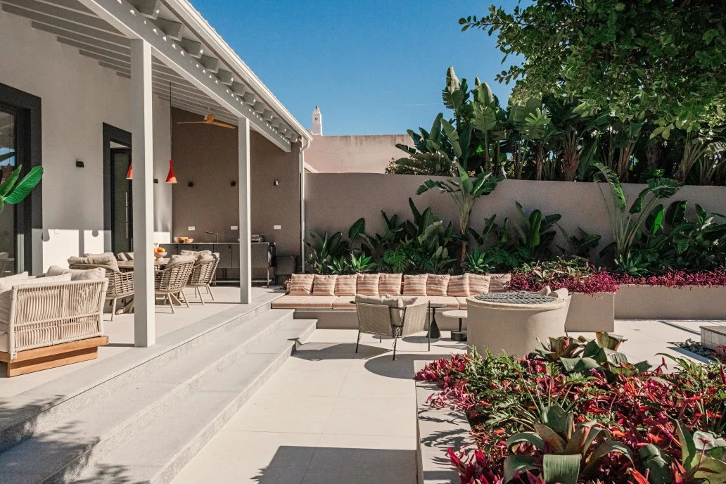 Outdoor patio with modern furniture, lush green plants, and a clear blue sky.  Holiday rental home in Lagoa.