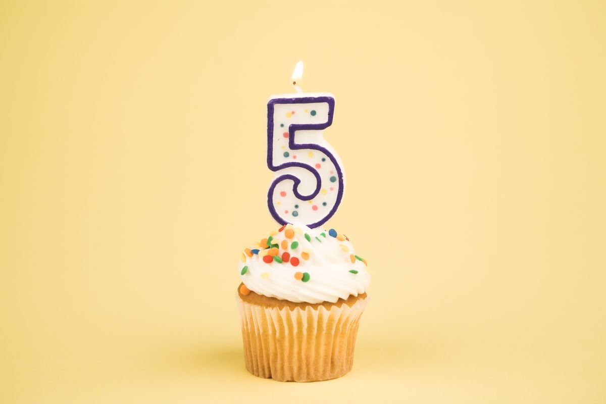 Cupcake mit Geburtstagskerze in Form einer Fünf – Sprachentwicklung im 5. Lebensjahr