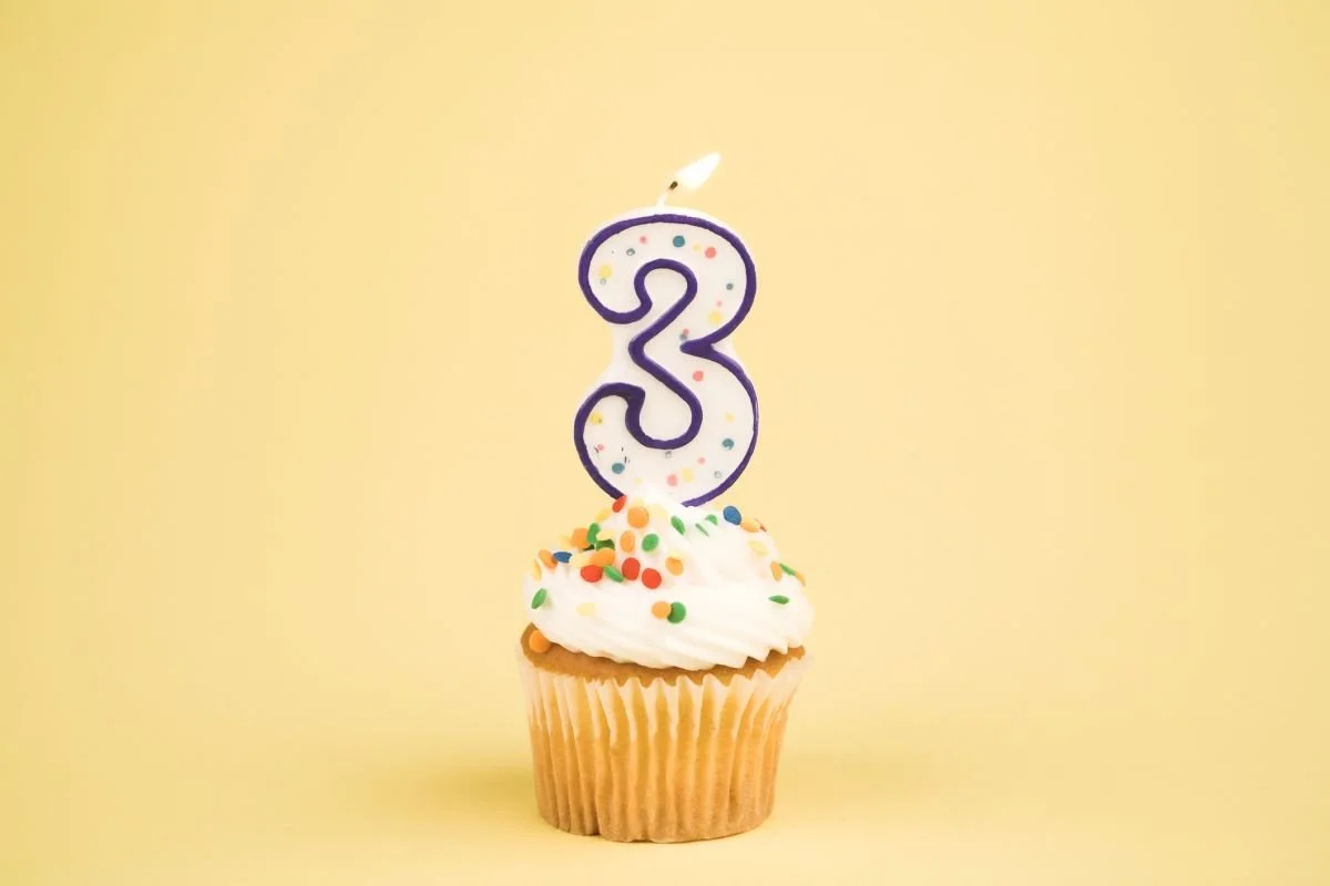 Cupcake mit Geburtstagskerze in Form einer Drei – Sprachentwicklung im 3. Lebensjahr