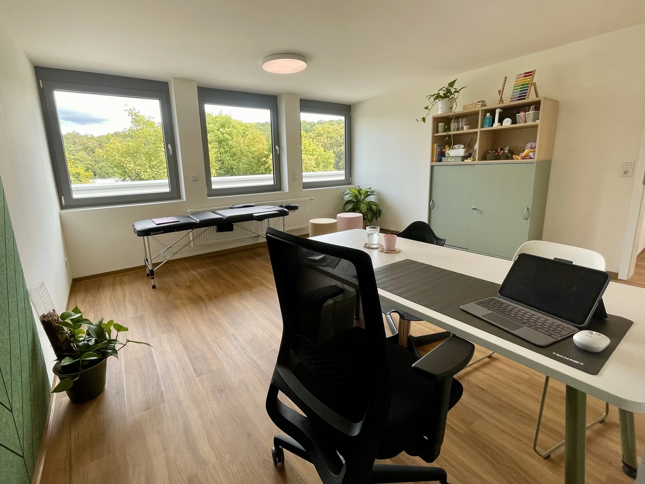 Moderner Therapieraum der Logopädiepraxis Stuttgart mit Arbeitsplatz und Therapieliege