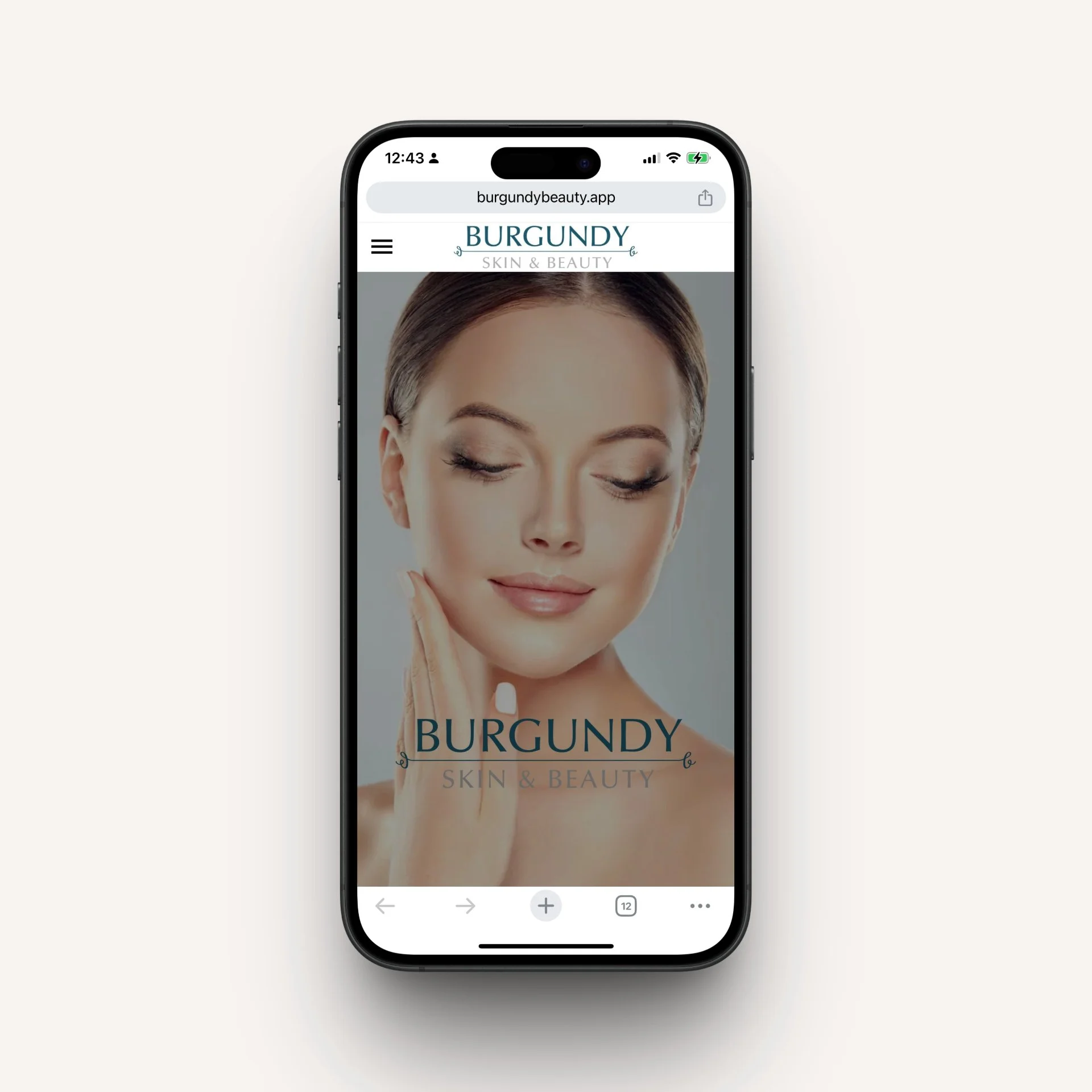 Smartphone displaying Burgundy Skin & Beauty website with a woman touching her face.