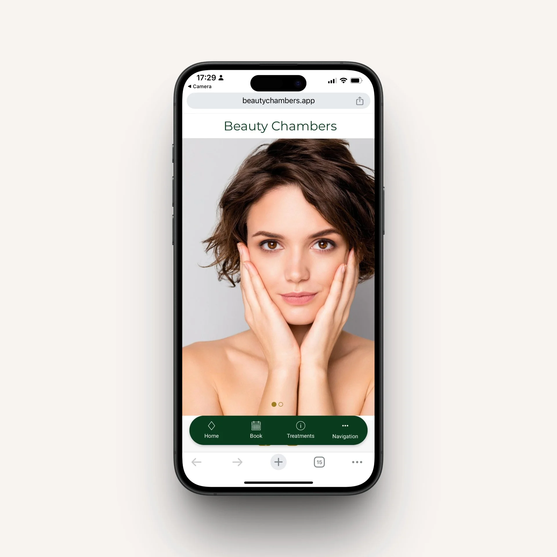 Smartphone displaying Beauty Chambers app with a woman touching her face on the screen.