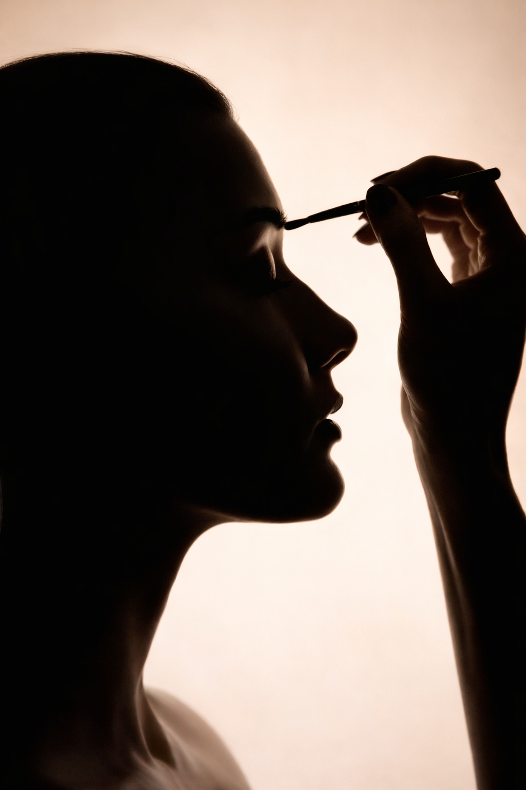 Schattenaufnahme einer Frau, die sich das Augen Make-up aufträgt.