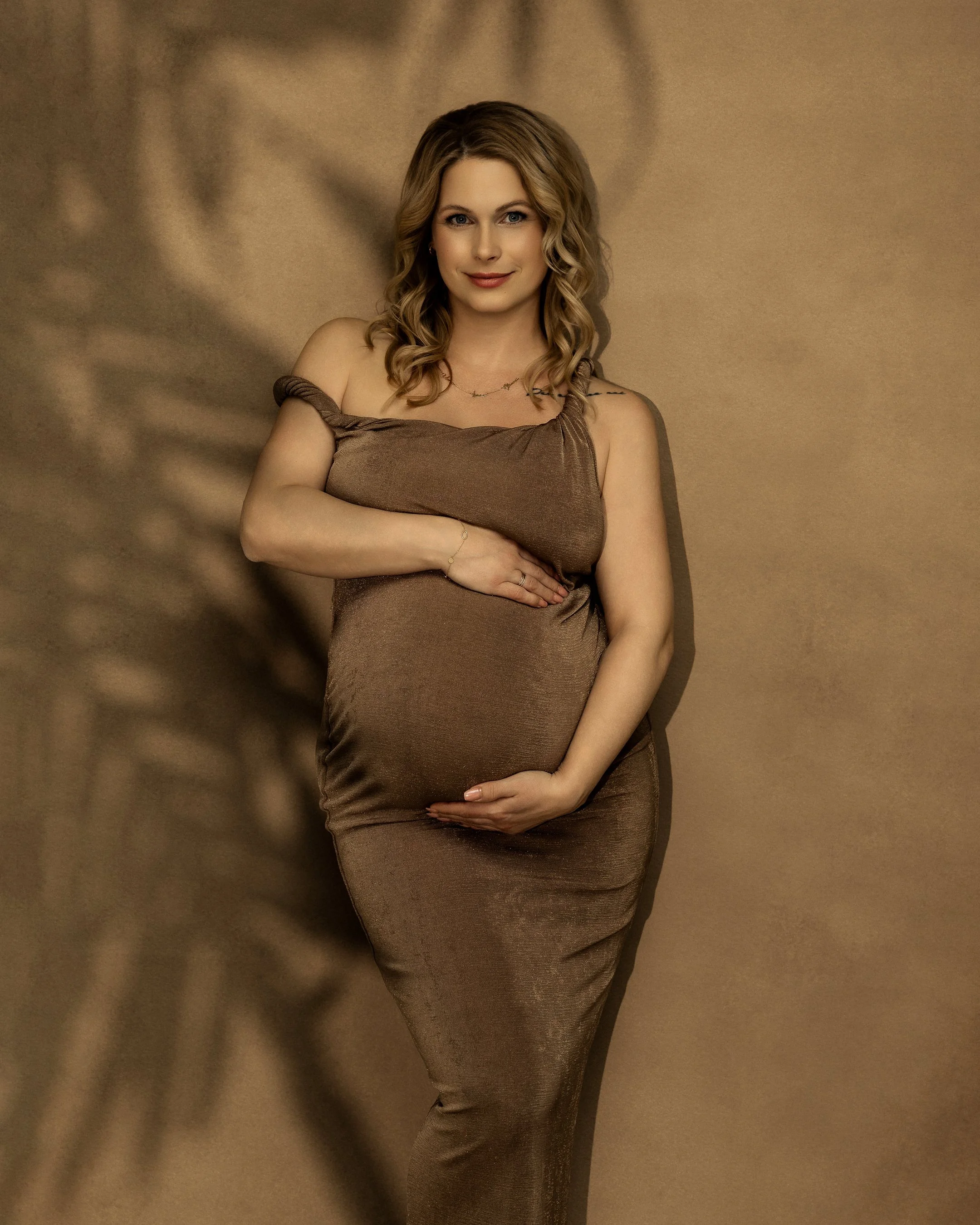 Wunderschöne blonde Frau in einem bodenlangen Abendkleid aus seegrünem Seidentaft