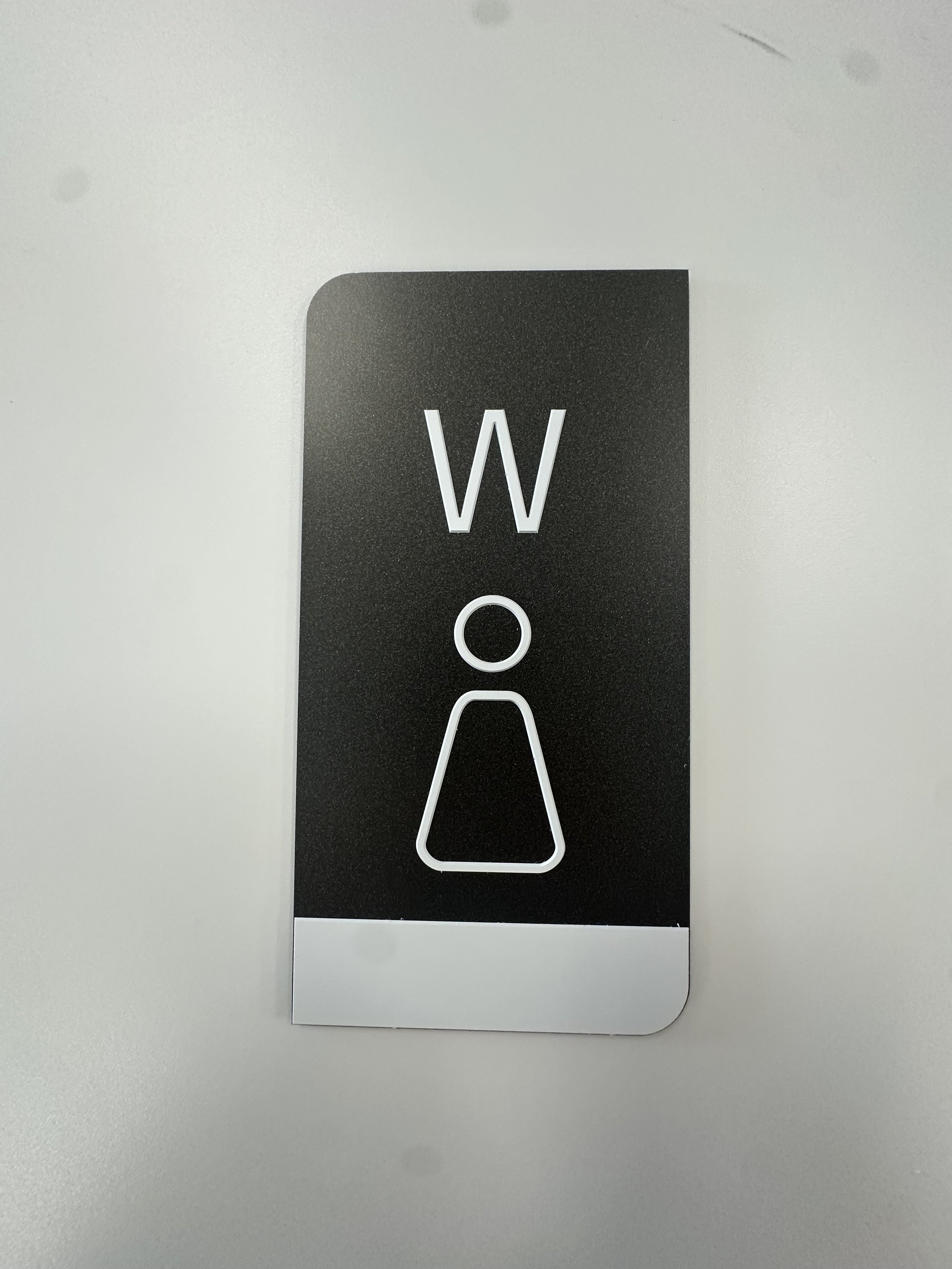 Women's restroom sign with a stylized female figure and the letter 'W' above it.