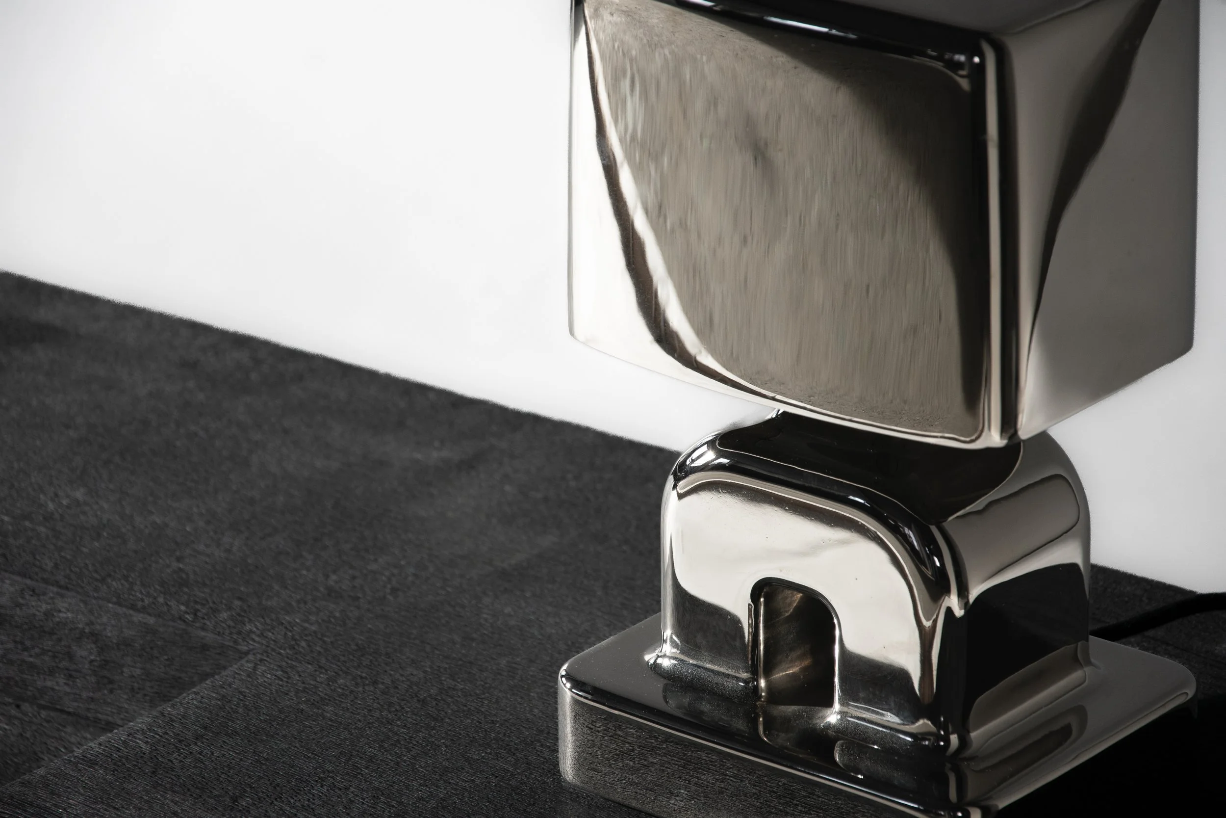 Close-up of a stainless steel coffee machine spout on a black countertop.