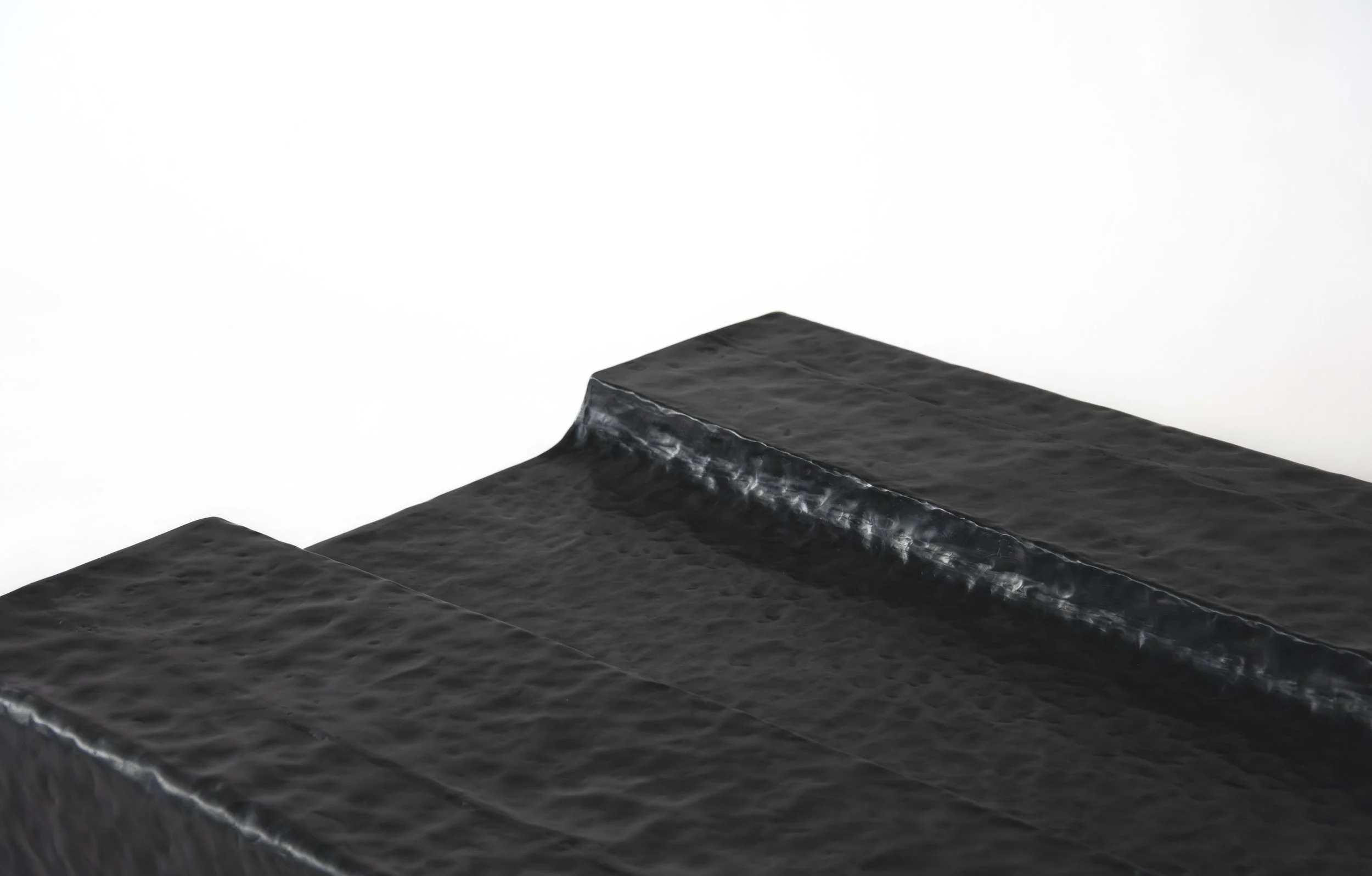 Close-up of three stacked black silica gel packets with crinkled texture against a white background.