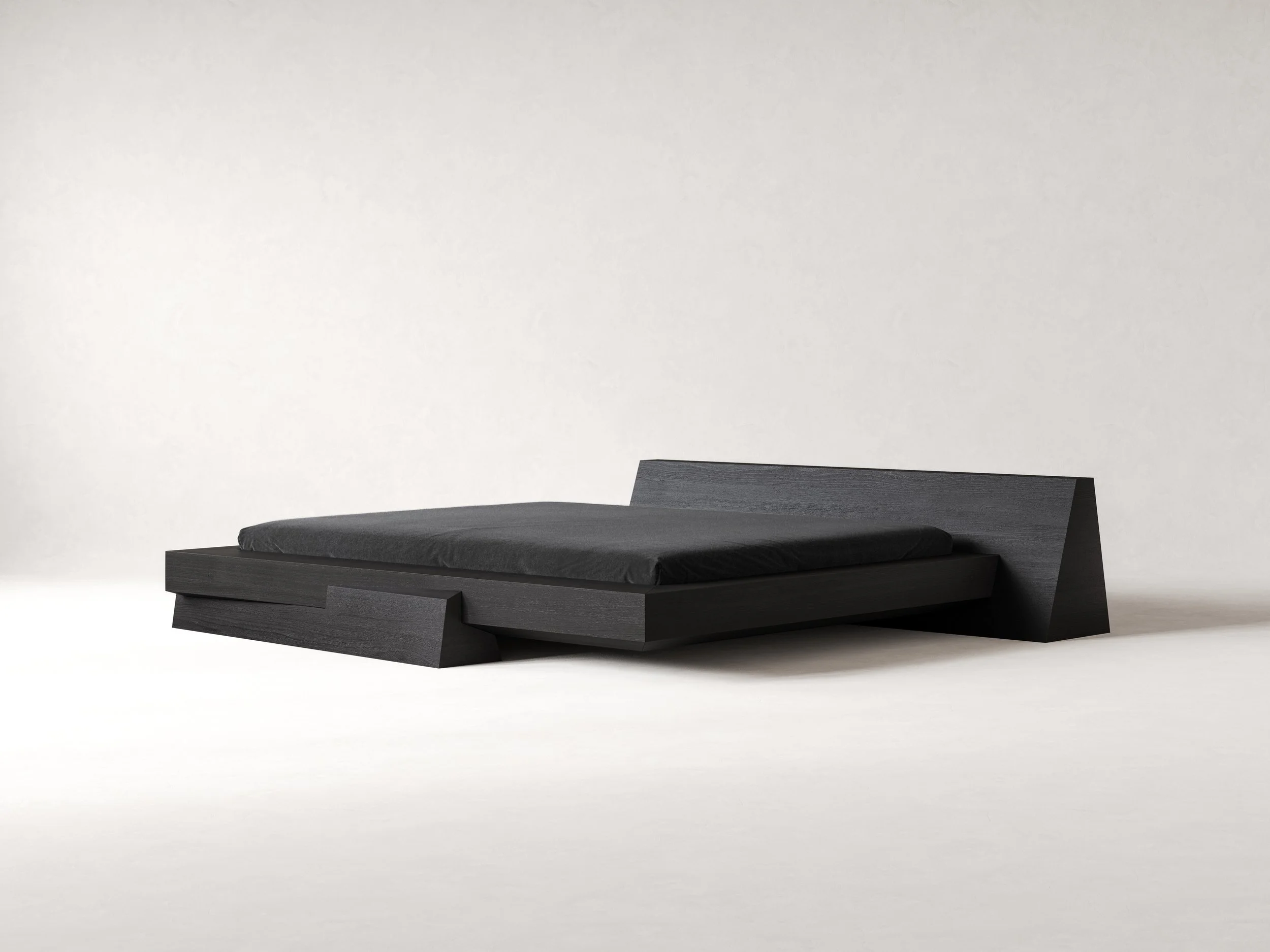 A modern black platform bed with a slightly angled headboard and low-profile design, set against a plain light gray background.