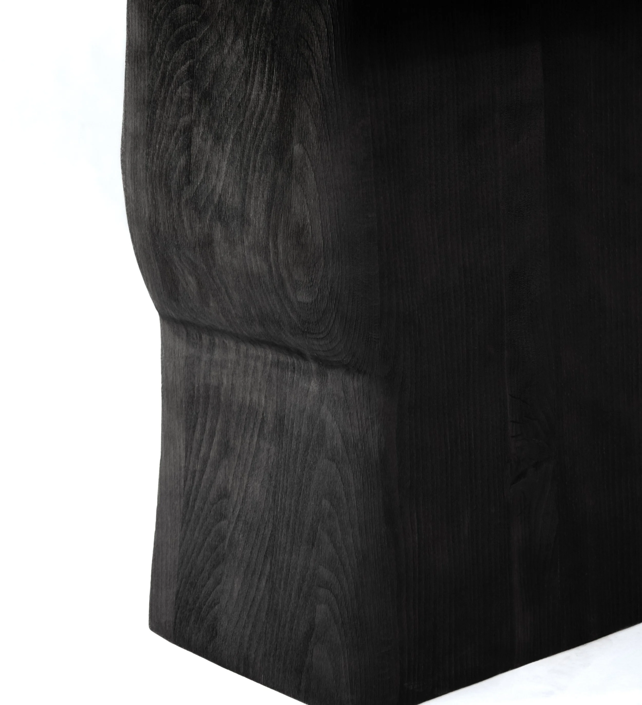 Close-up of a black wooden sculpture showing the detailed grain and texture of the wood.