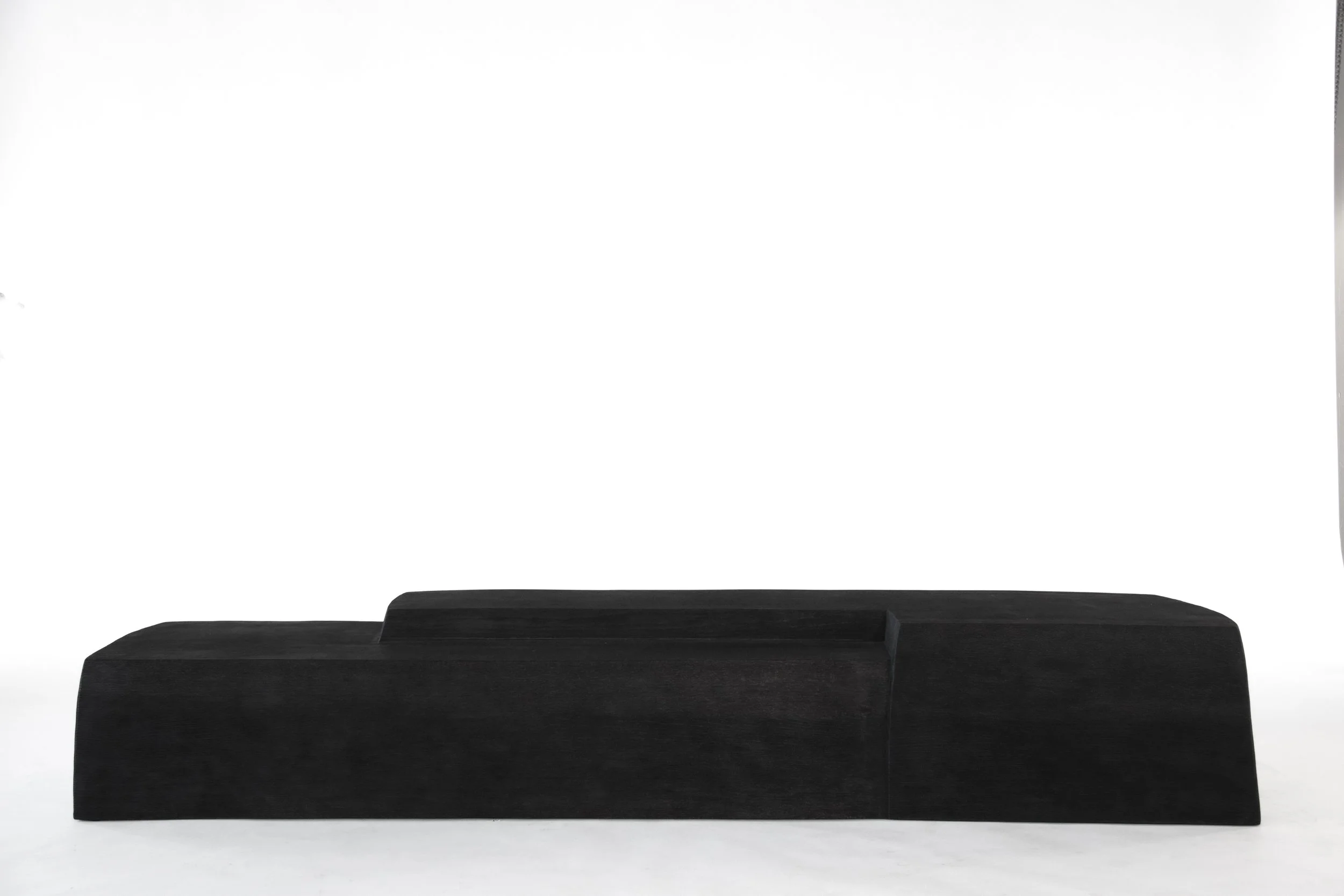 A black minimalist sideboard with a step-like design in front of a plain white background.