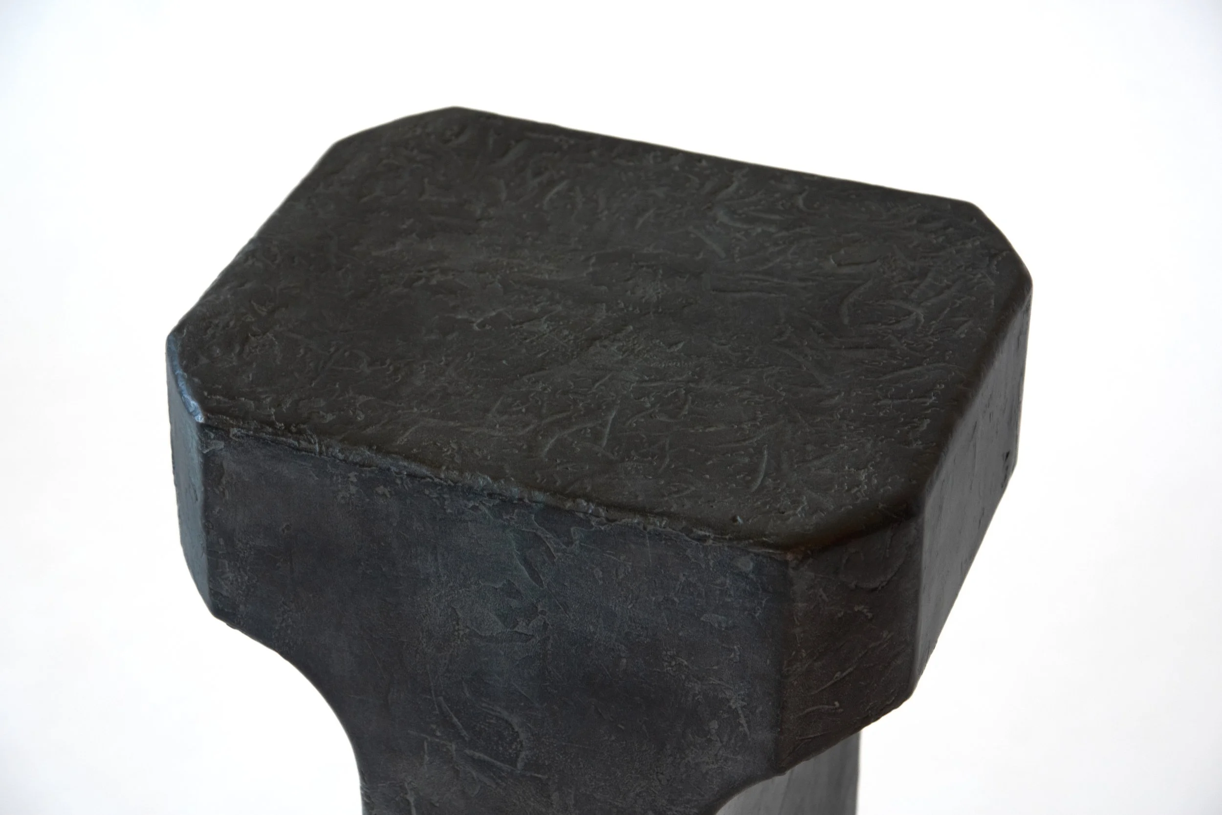 Close-up of a black hammer head with a textured surface, isolated on a white background.