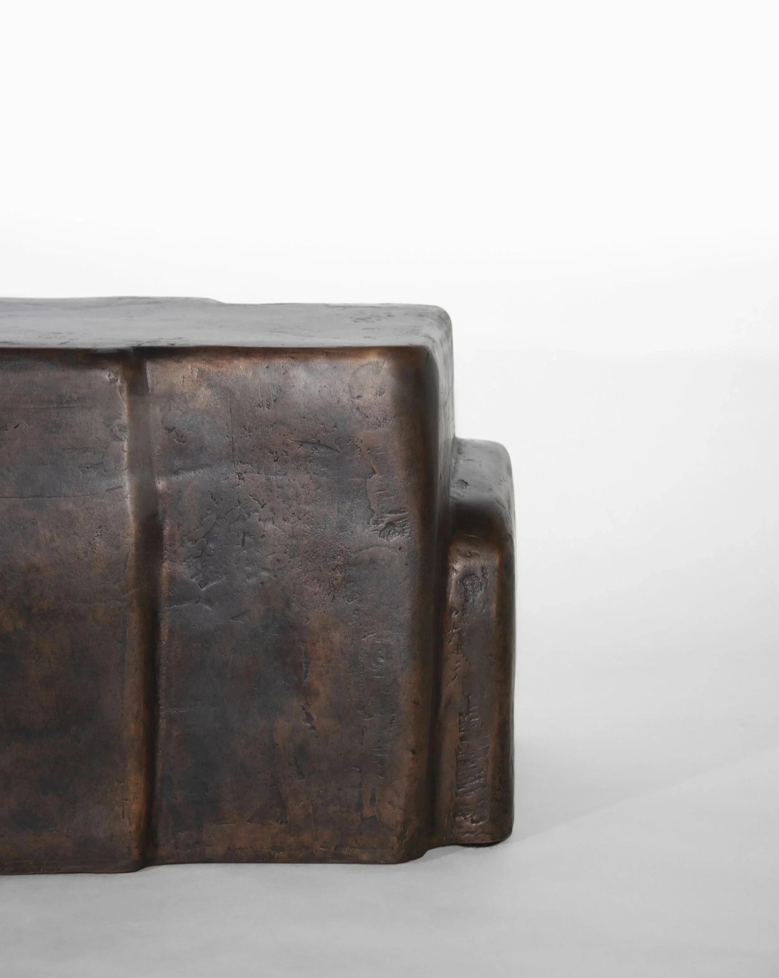 Close-up of a vintage, rusted metallic-timecopper-colored box or base with a textured surface and smooth edges against a plain white background.