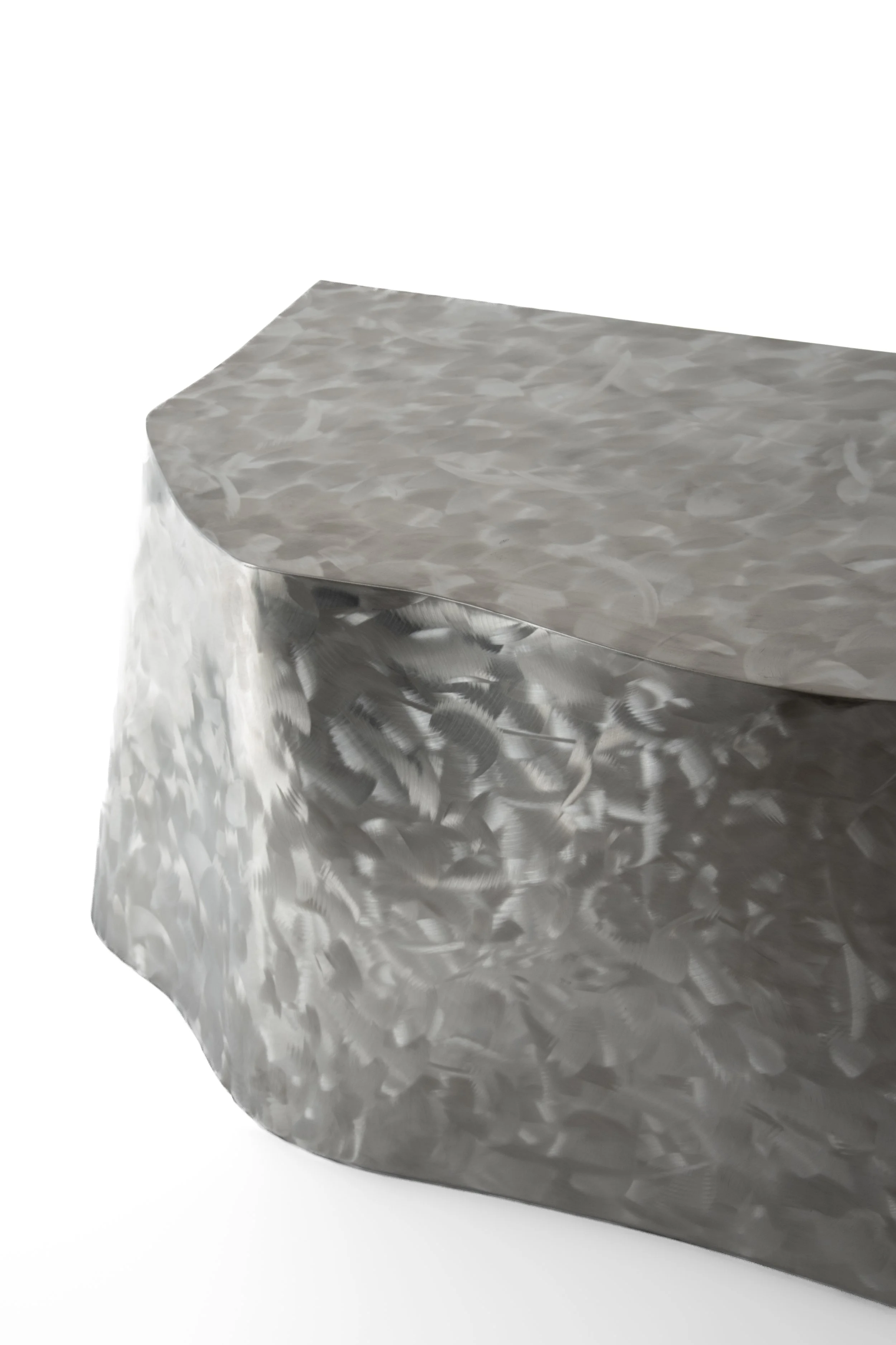 A metallic table with a textured, hammered finish, featuring a rectangular top with rounded edges.