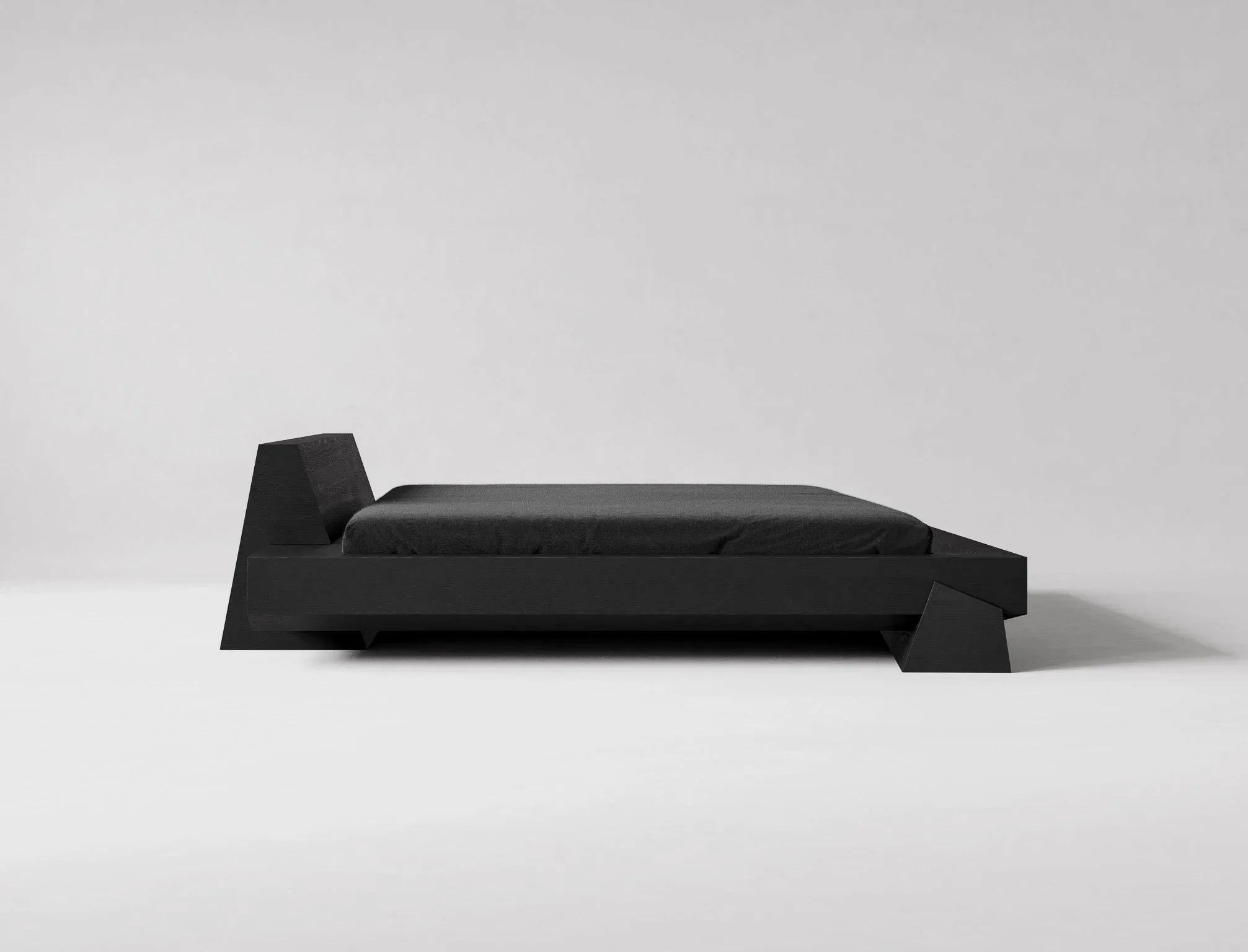 A modern black bed with geometric design, black bedding, and a minimalist aesthetic against a plain white background.