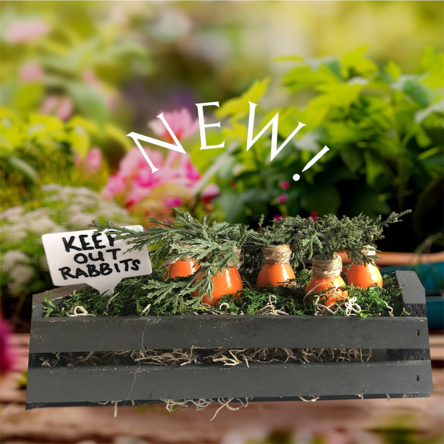 A group of painted carrots inside a small black crate with greenery
