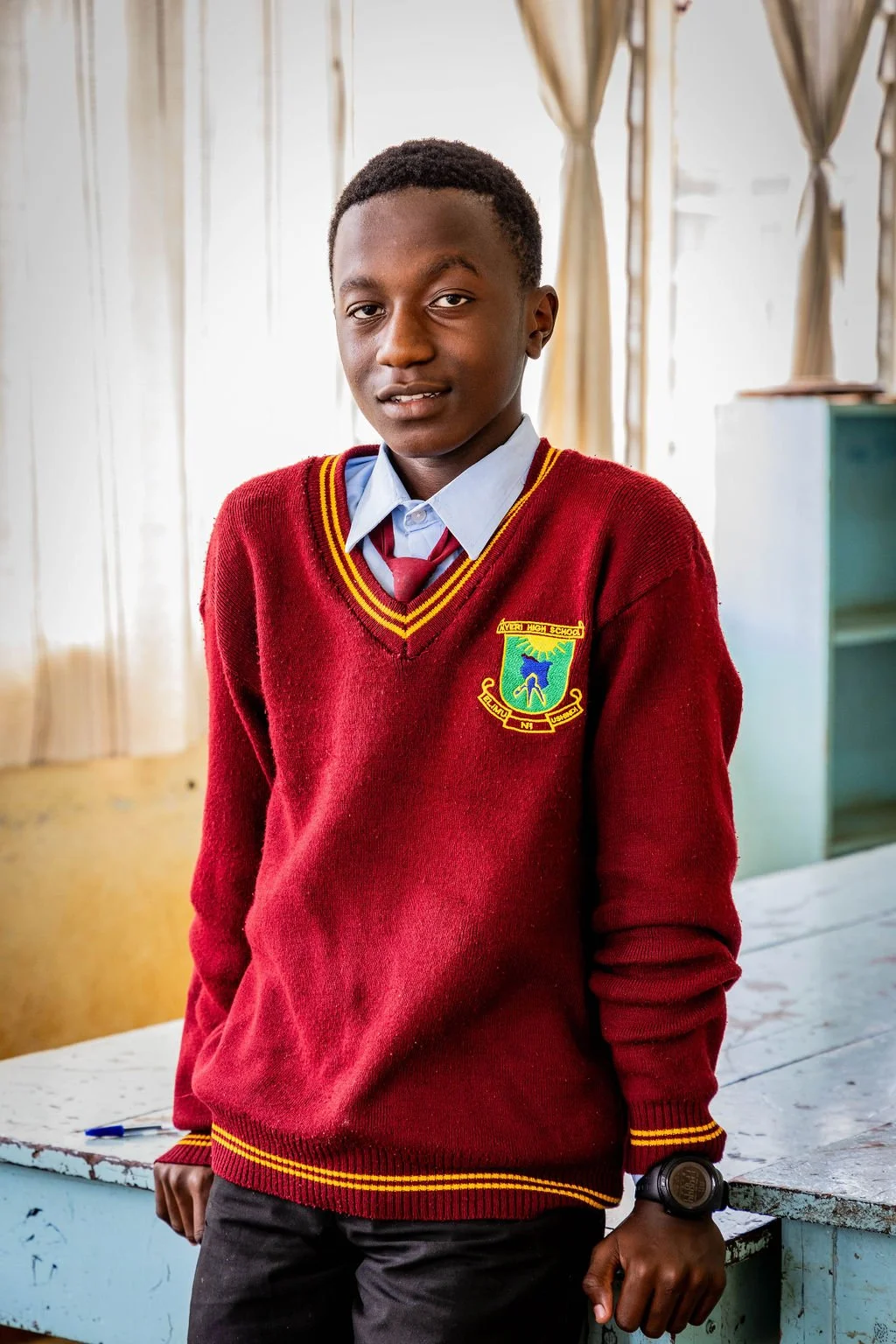 Student wearing a maroon school sweater with emblem