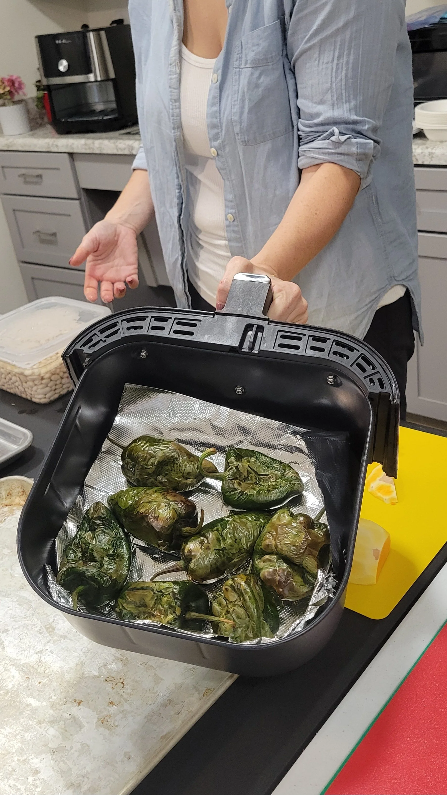 Blistered poblano peppers in an air fryer for a soup ingredient.