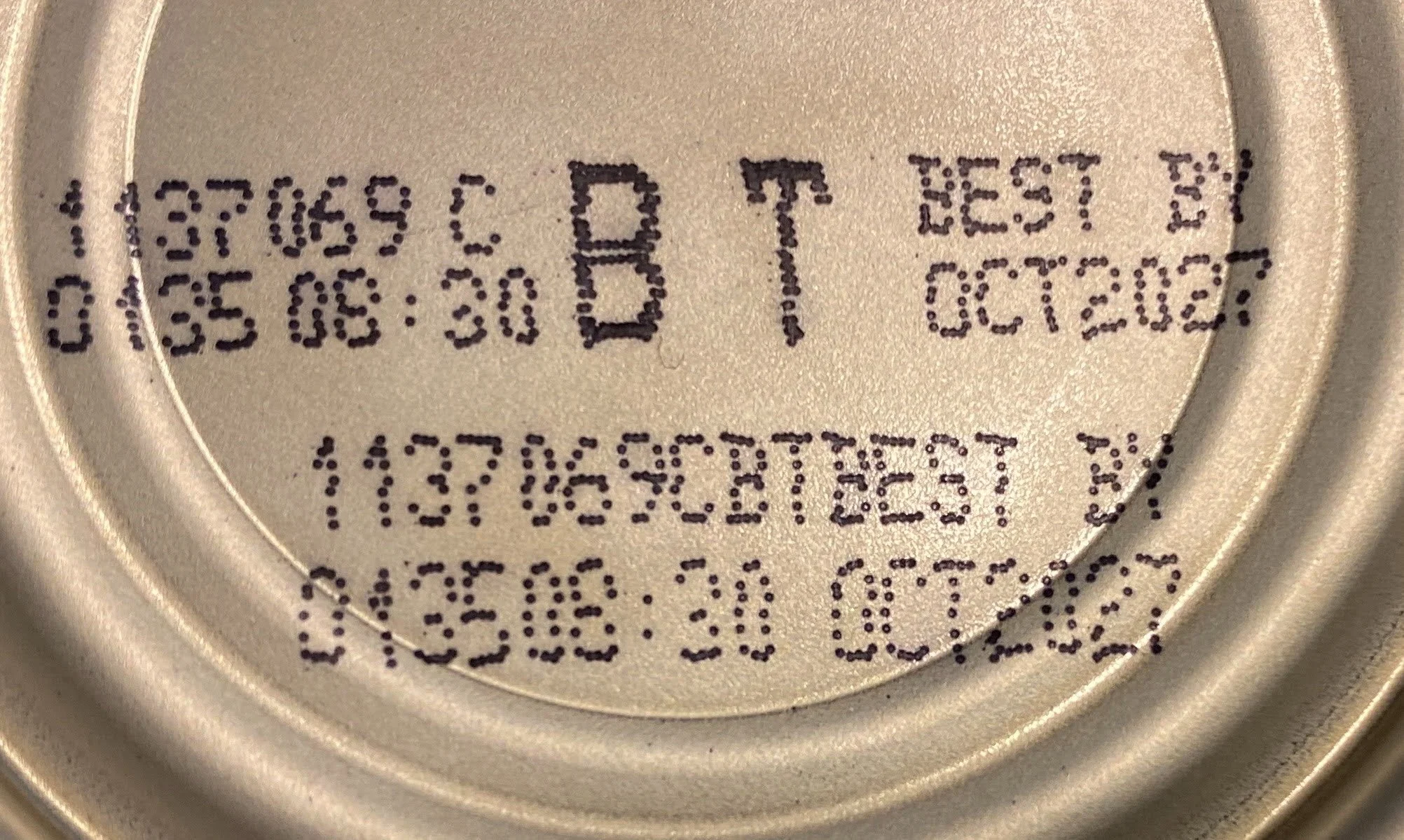 A can lid with both open and closed date food labels.