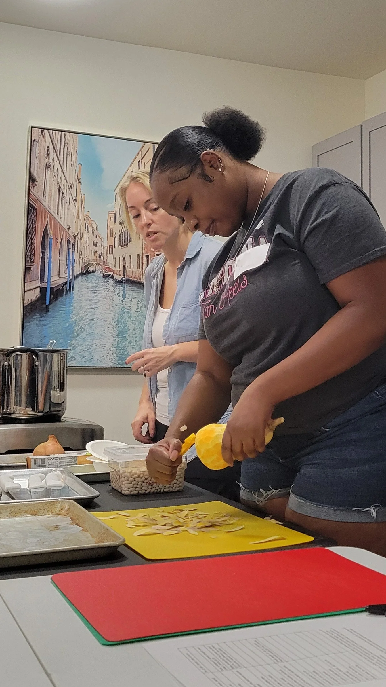 Kitchen Compass client peeling the skin off a butternut squash.