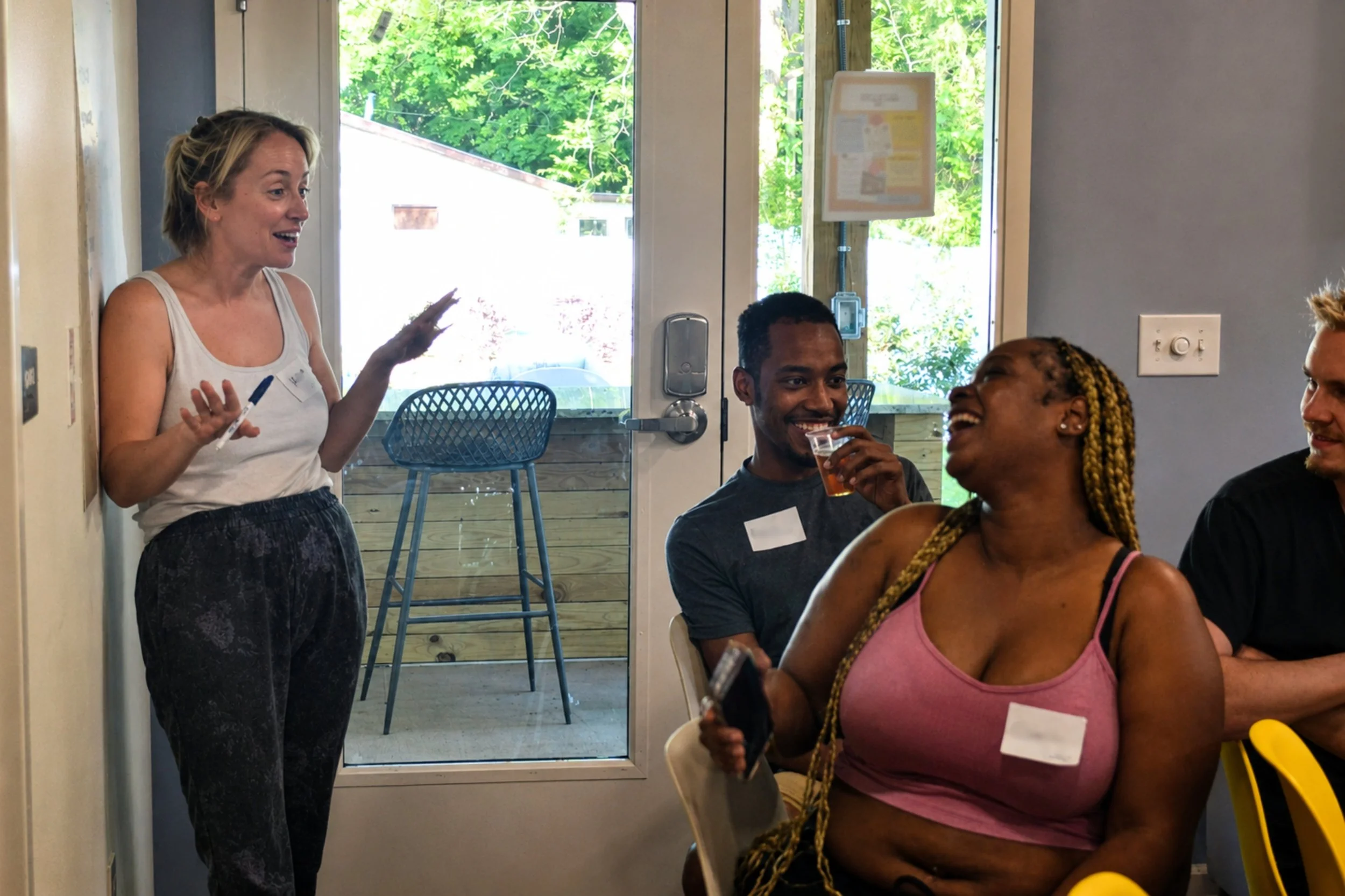 Kait of Burkett Farm laughing with smiling Kitchen Compass clients as they brainstorm food topics they want to learn about.