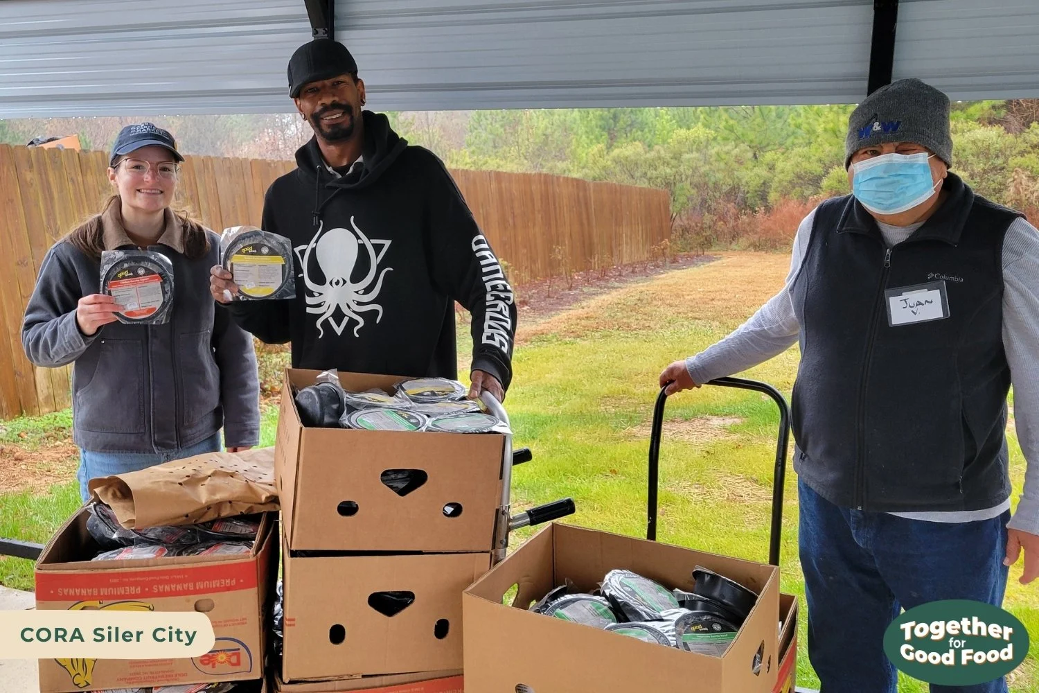 Tori Wierzchowski of Food Equity Collaborative and two CORA Siler City staff stand behind a cart full of boxes of Good Bowls. 