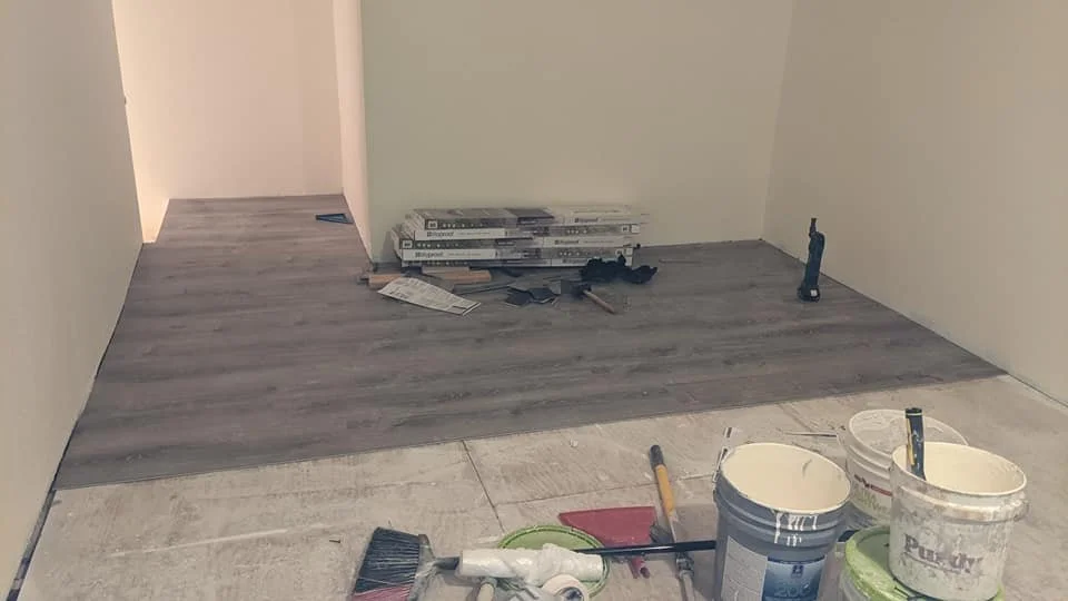 Room undergoing flooring installation.