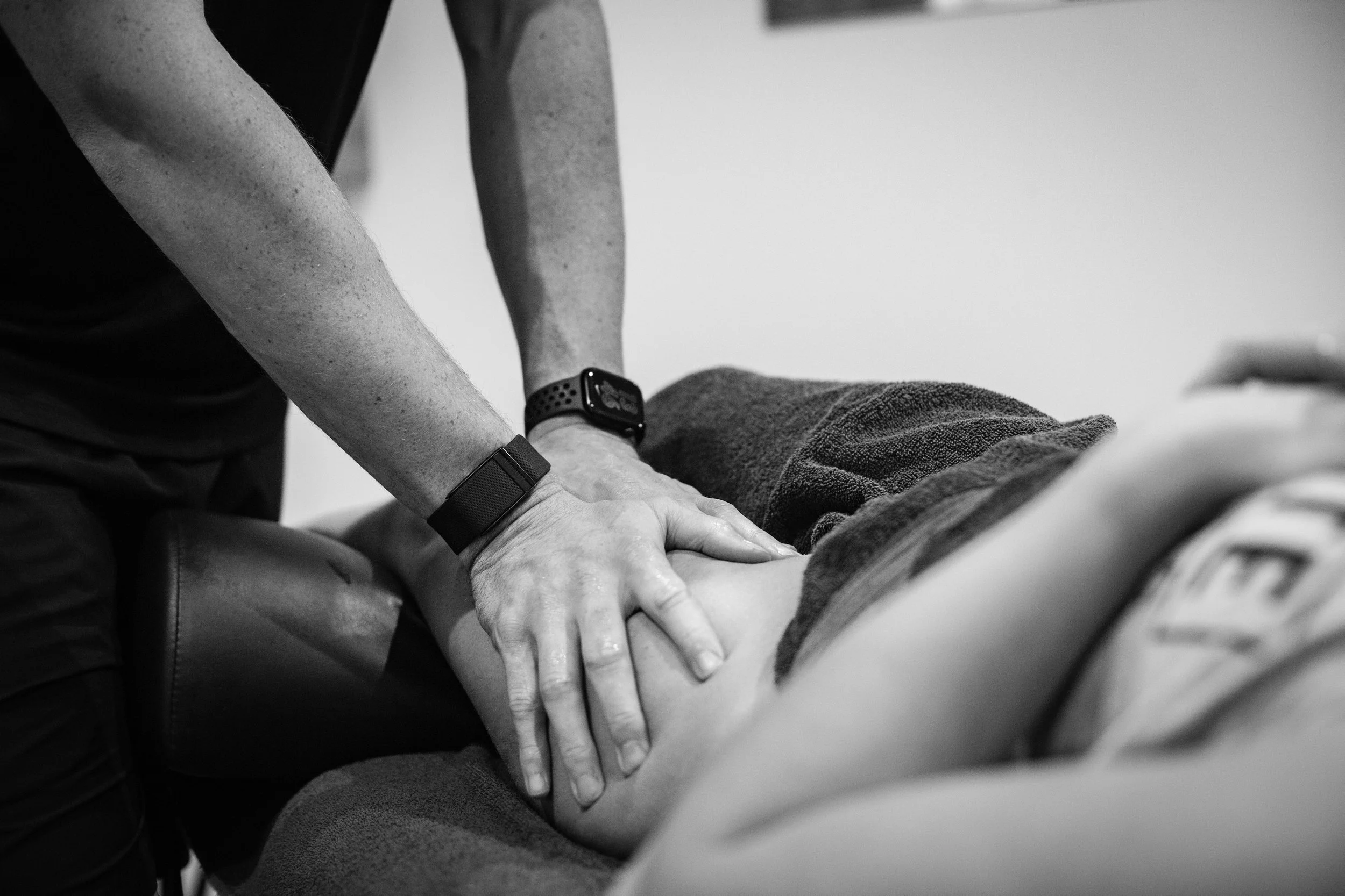 A person providing chest compressions during CPR on someone lying on a table.