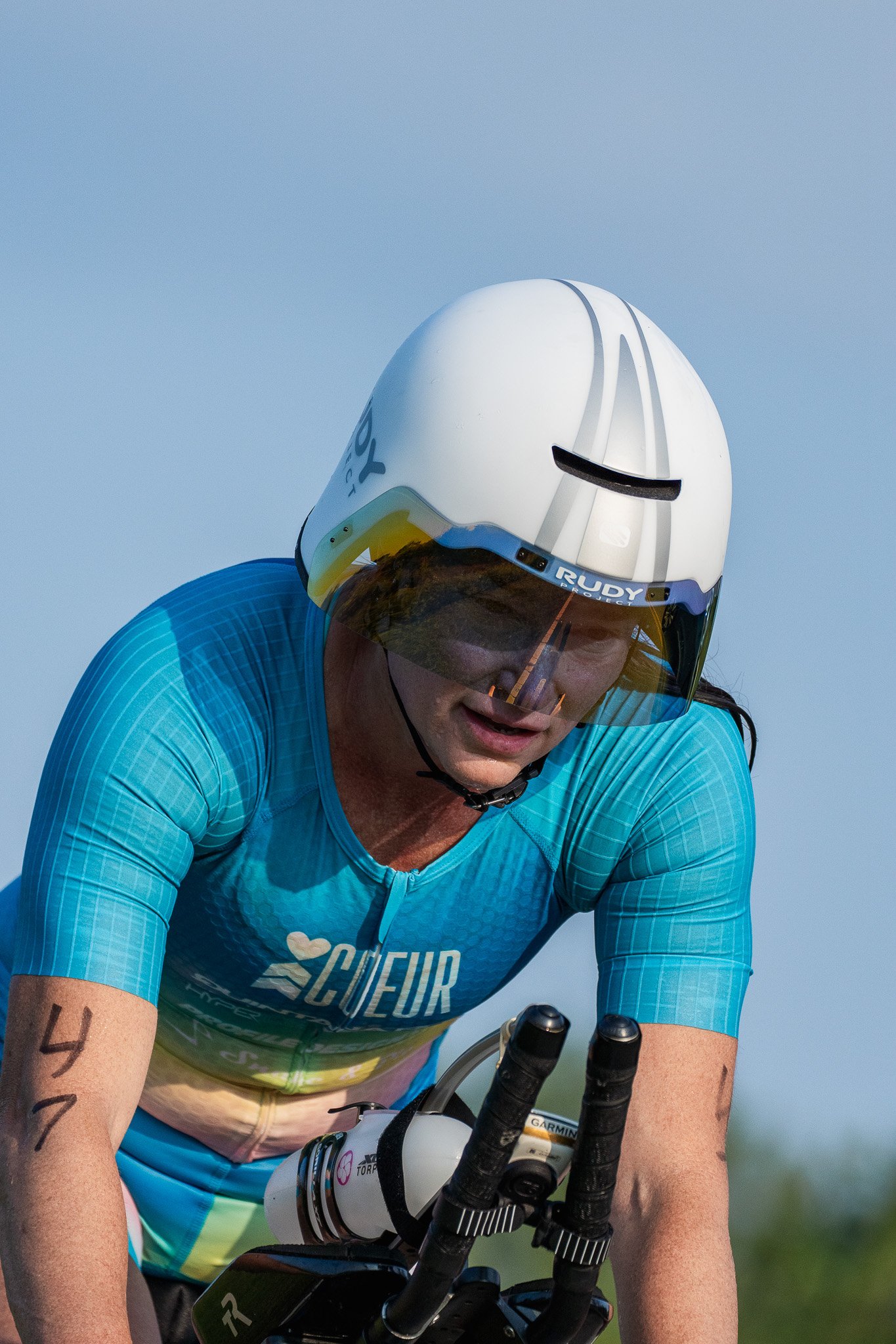 Woman in a white aero helmet cycles a triathlon