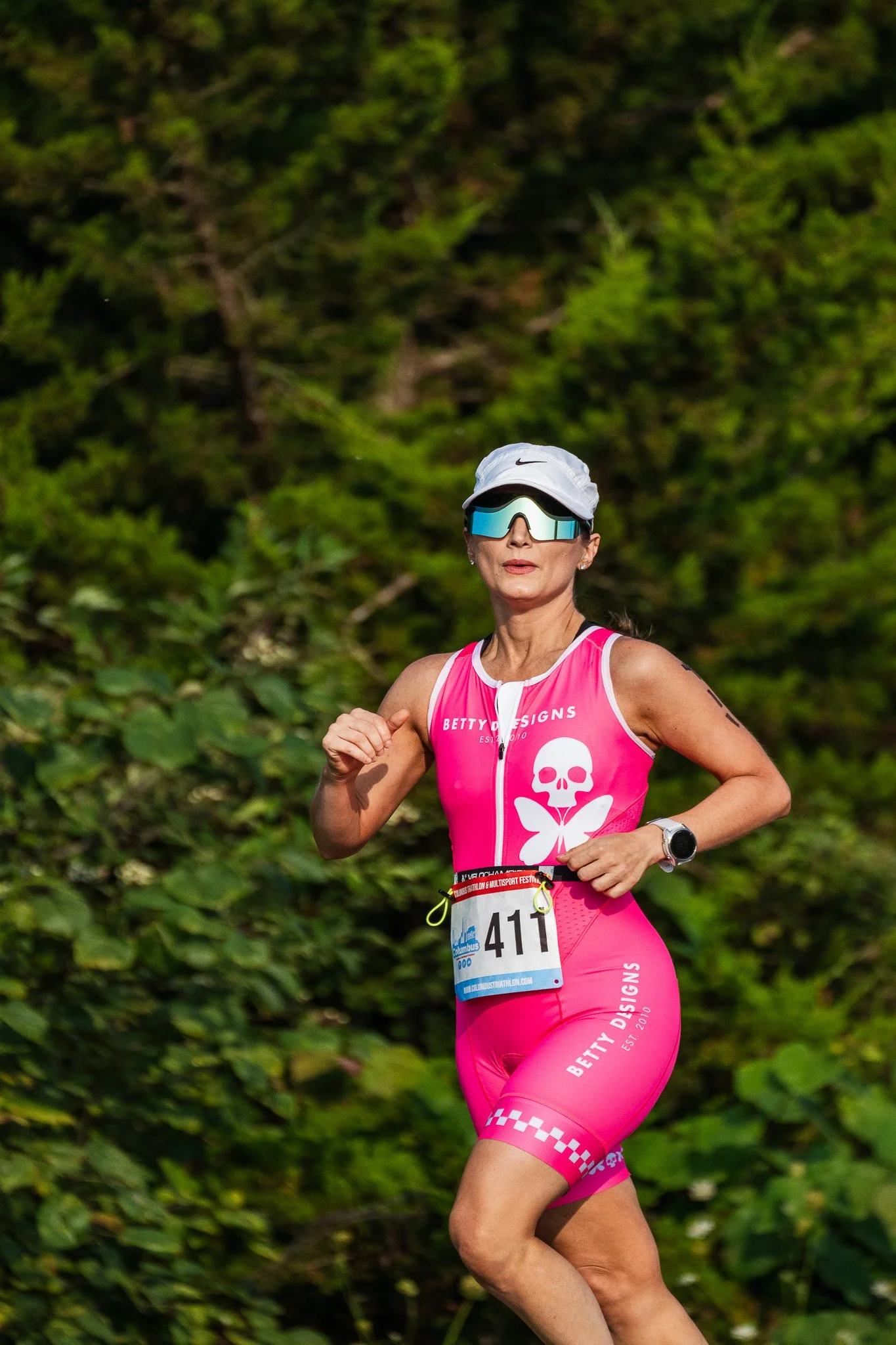 Woman in all pink trisuit runs in a triathlon
