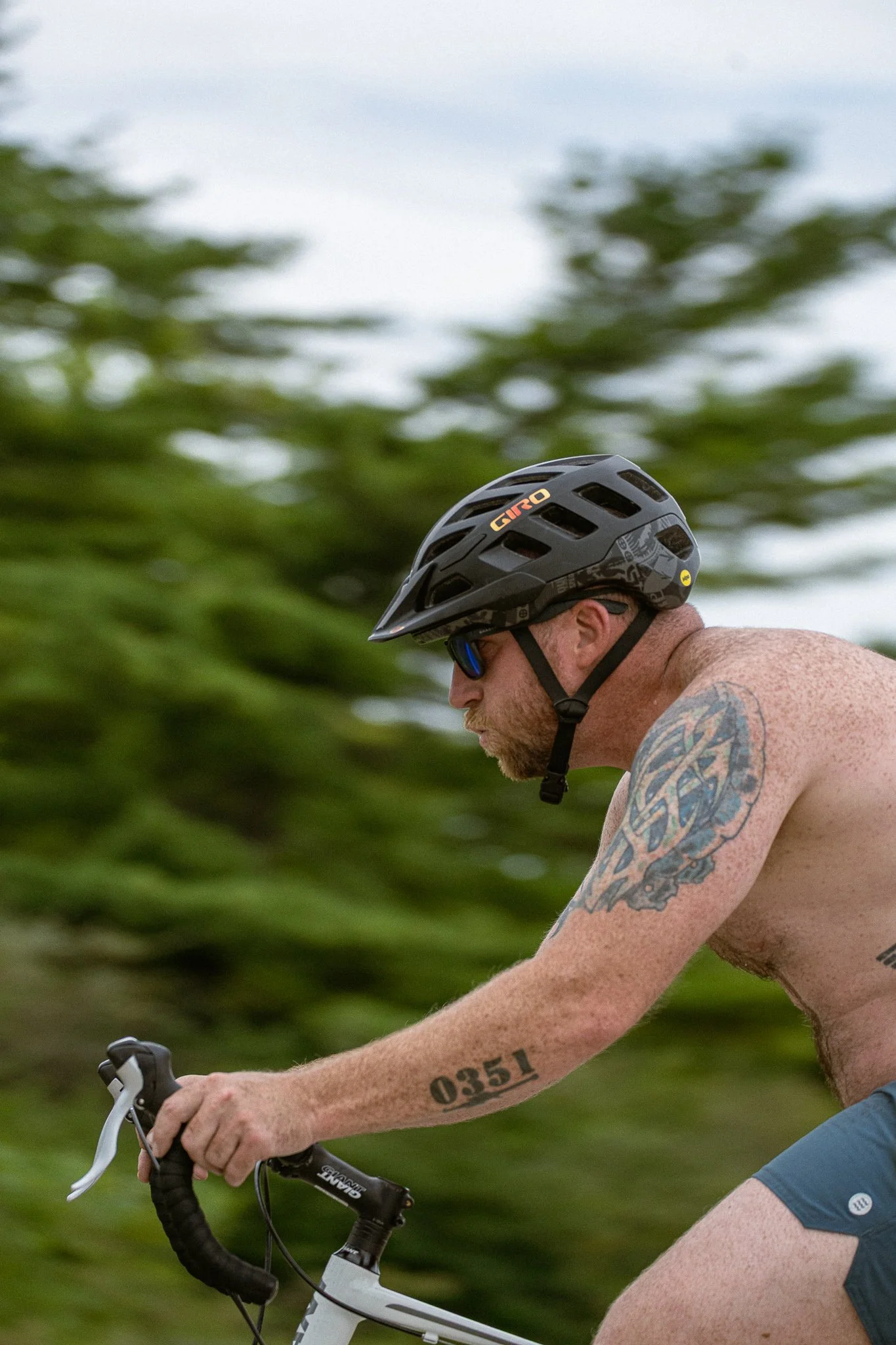 Portrait of shirtless male triathlete biking with a blurred background
