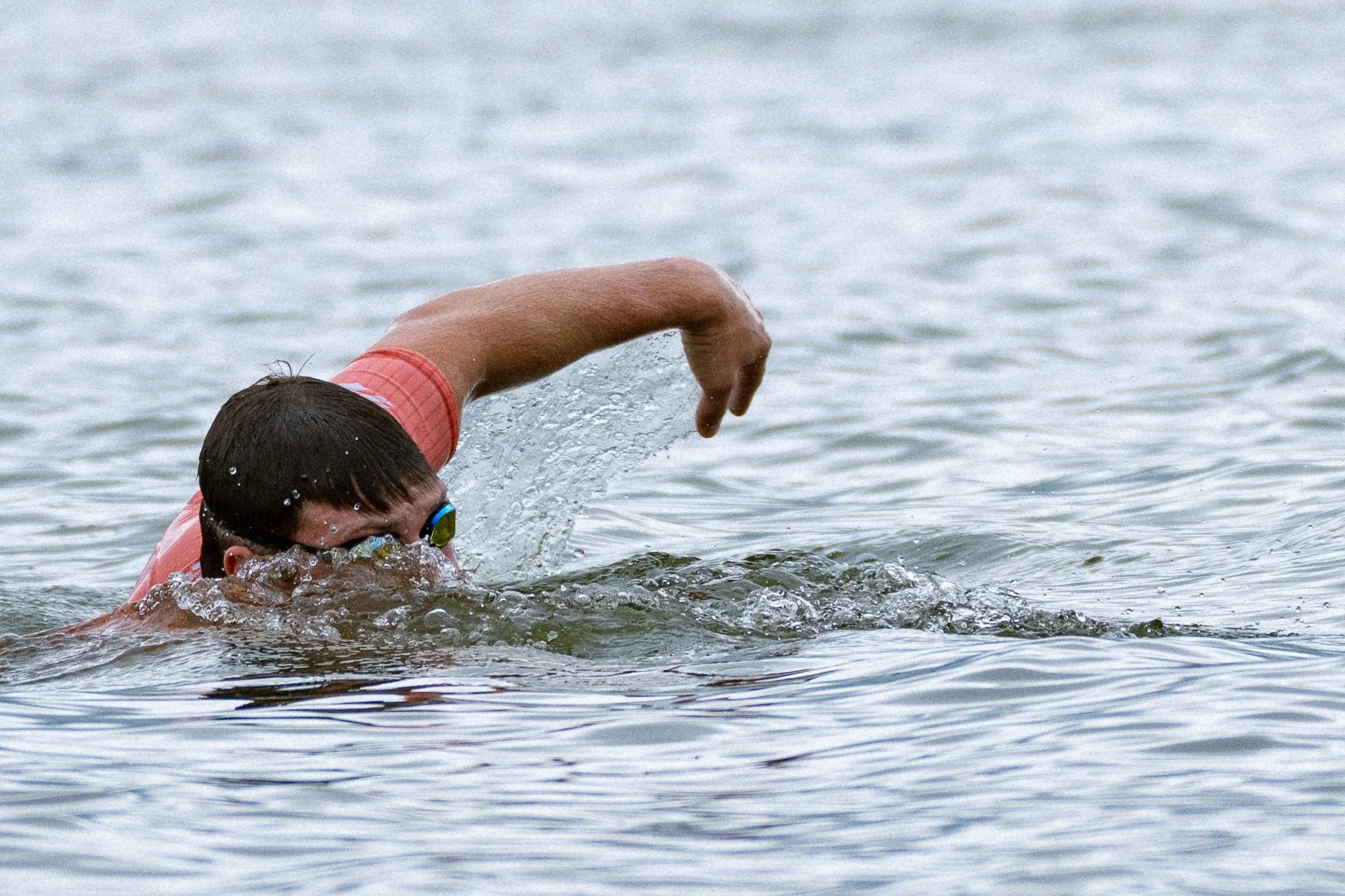 Male triathlete looks up during swim portion while training