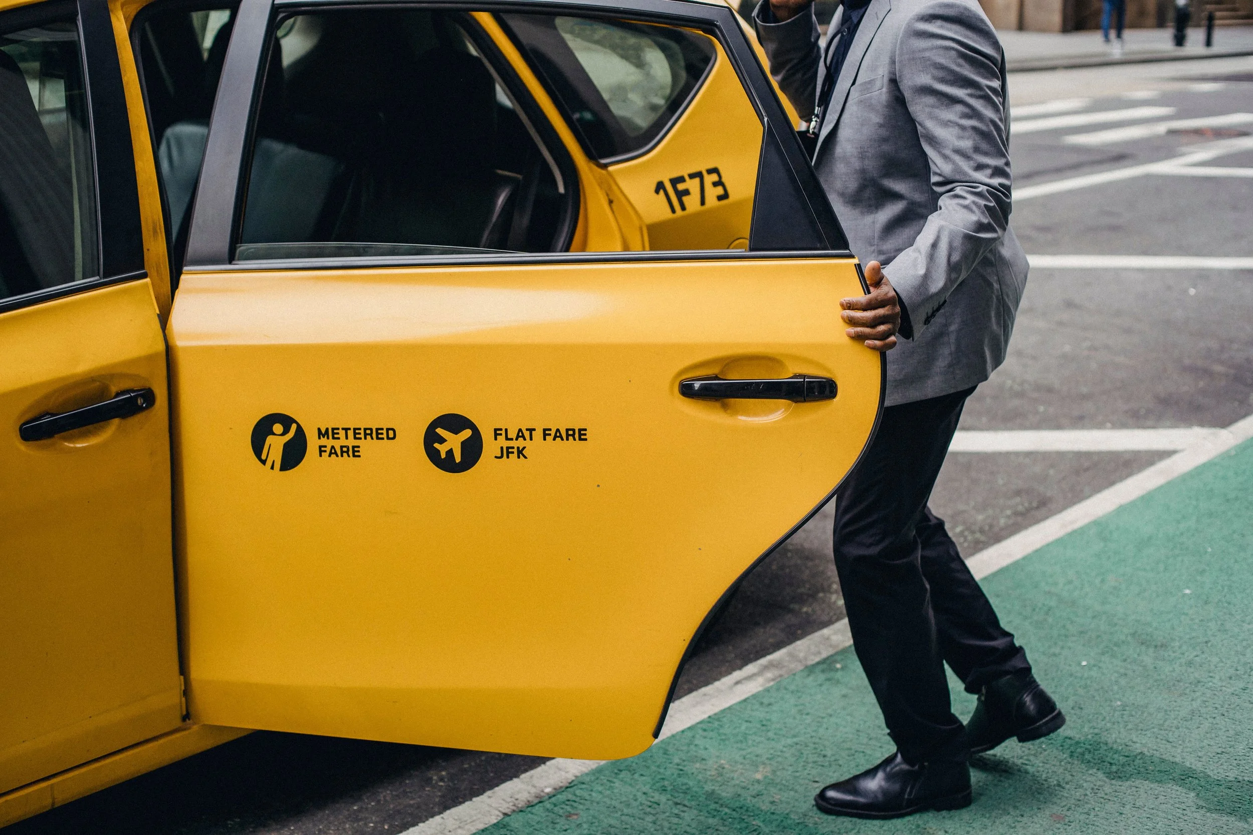 Passenger opening the back door of a yellow cab, representing rideshare passenger accidents and injury claims