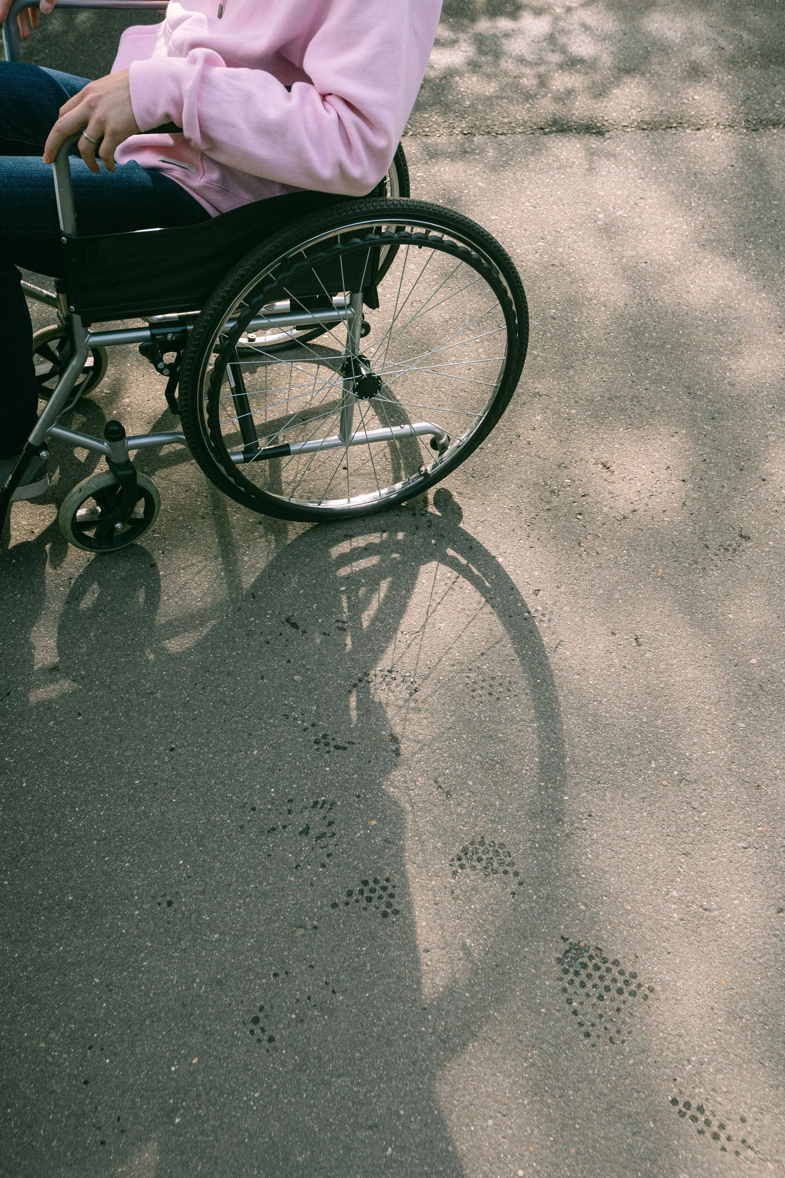Person seated in a wheelchair outdoors, representing life after a spinal cord injury or paralysis